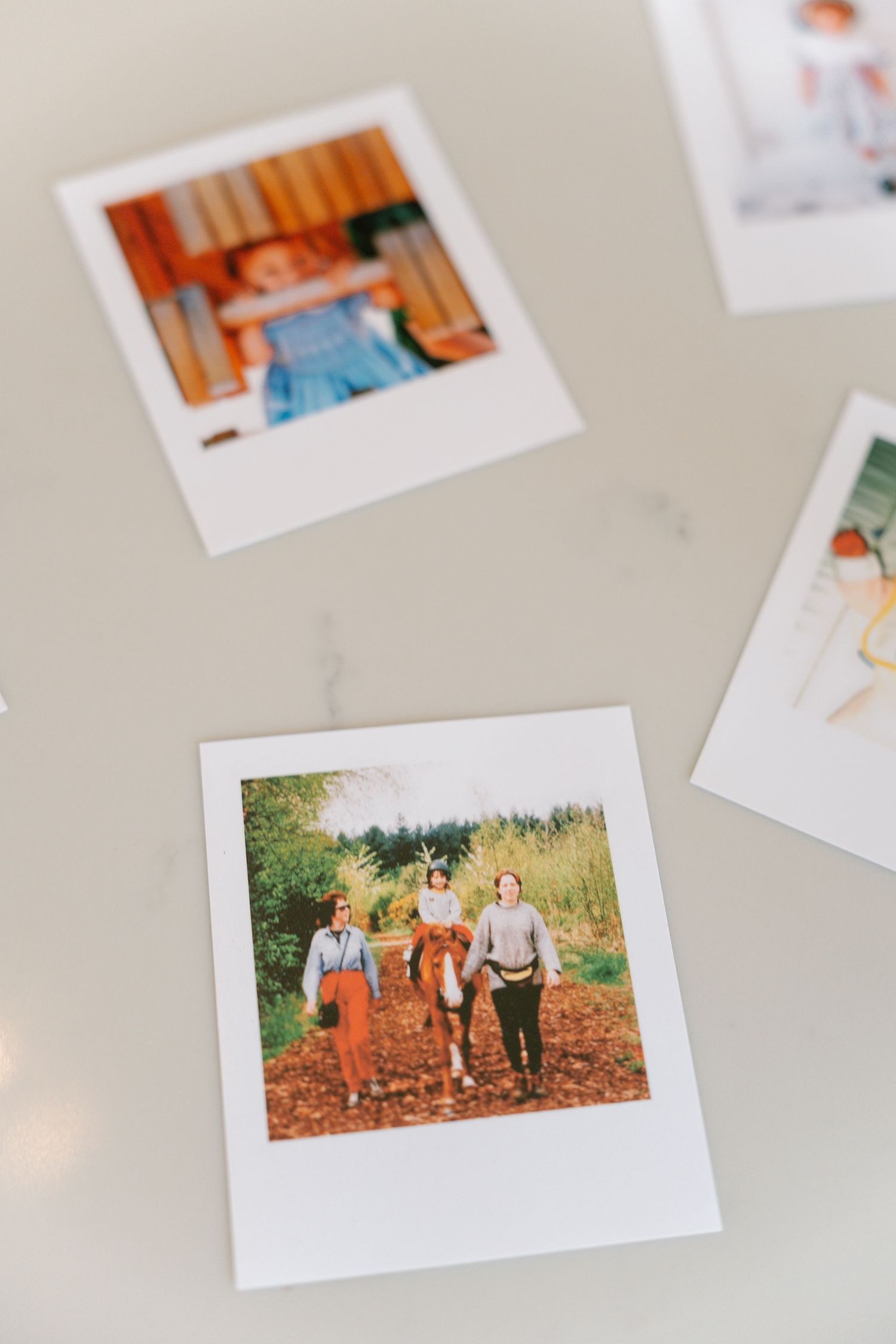 Collection of family photographs scattered on a light colored surface.