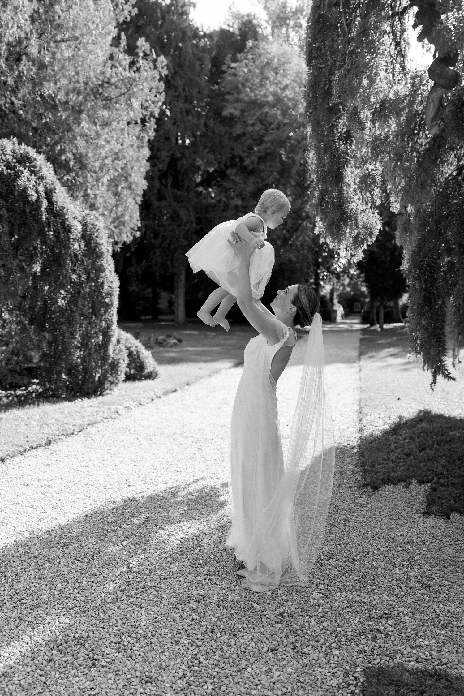 Black and white sequence of a flowing white dress twirling in a garden path.