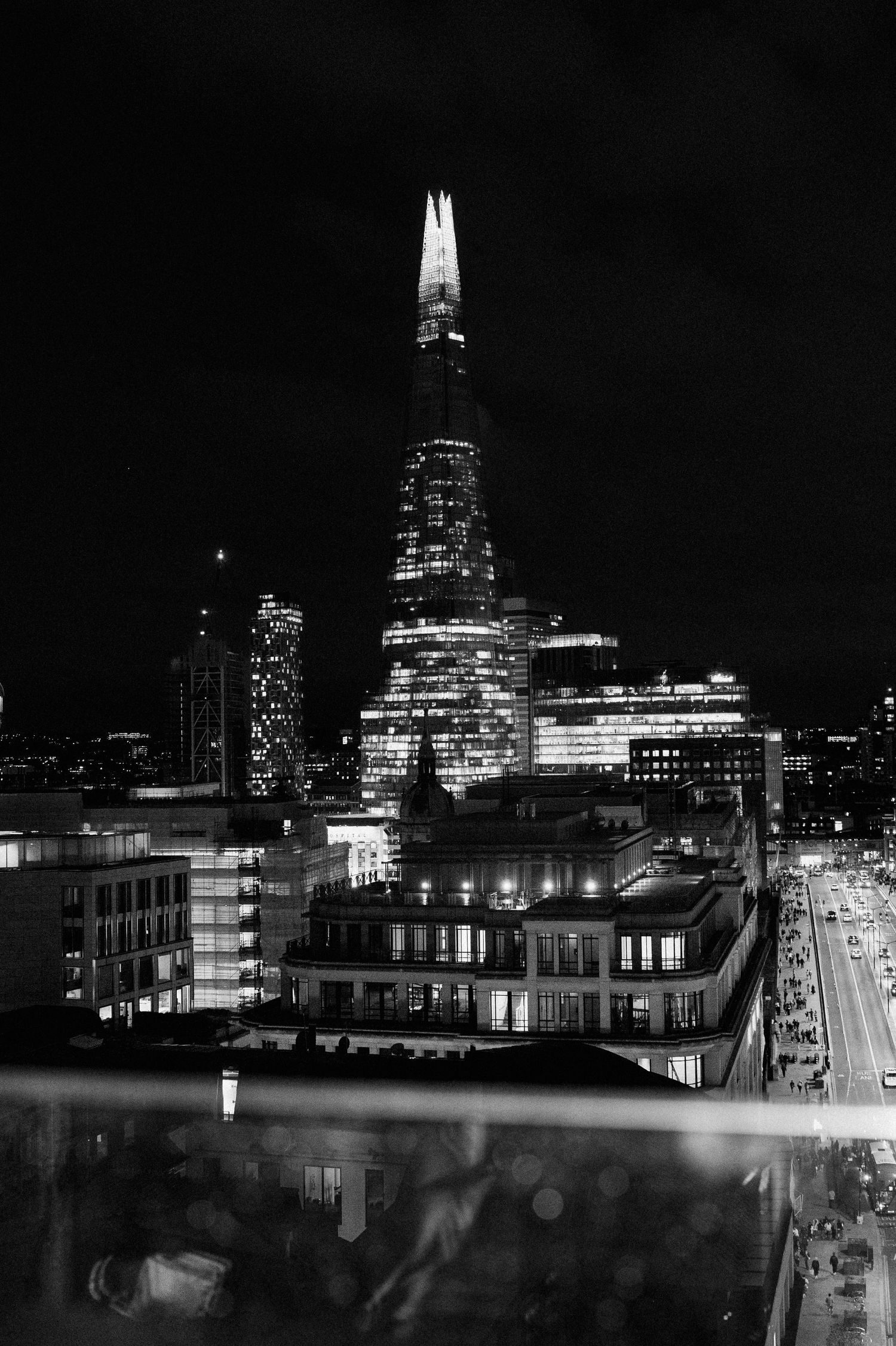 Nighttime cityscape of London showing illuminated buildings and The Shard.
