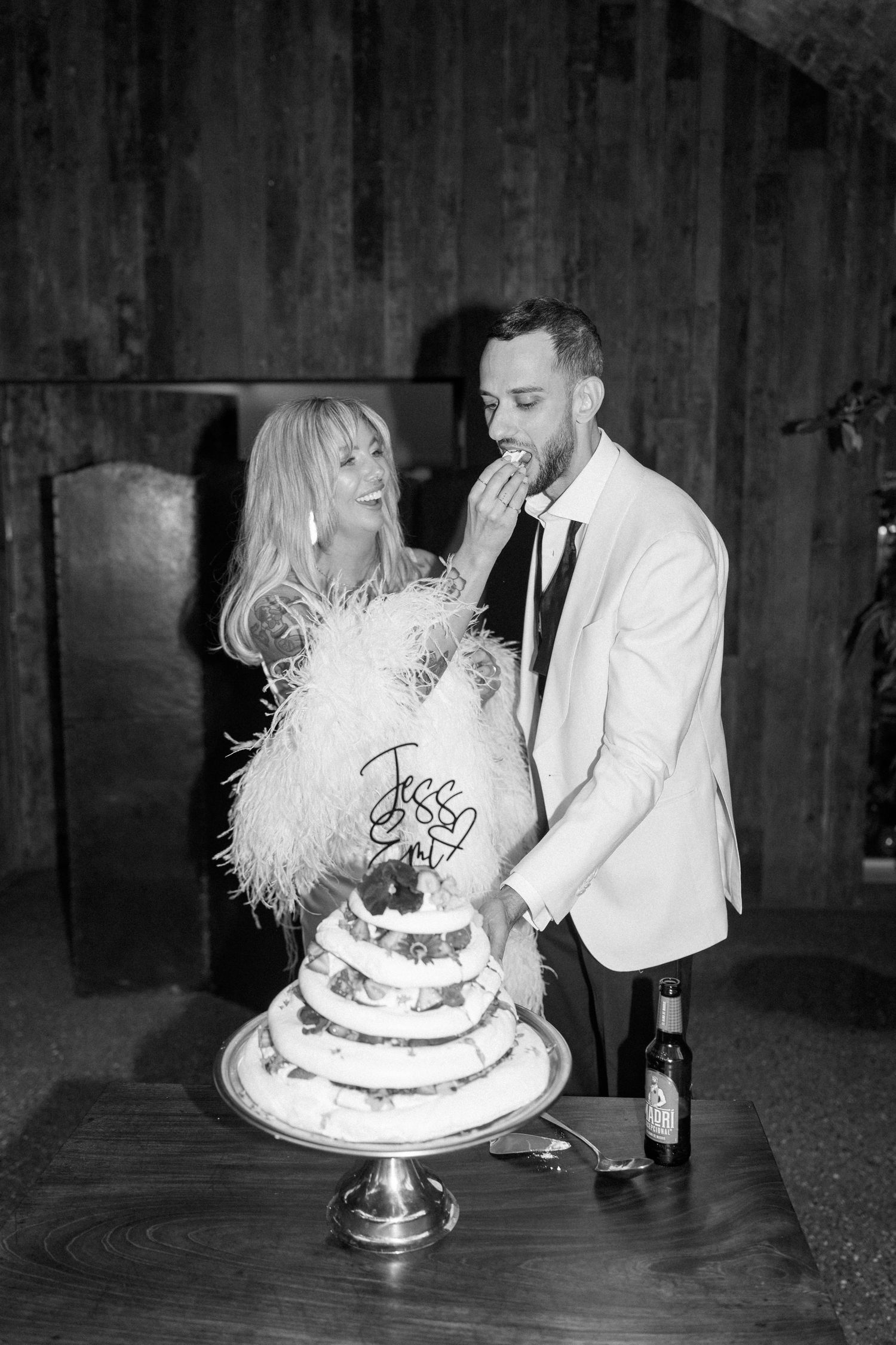 Black and white photos of couple enjoying their wedding cake at the reception.