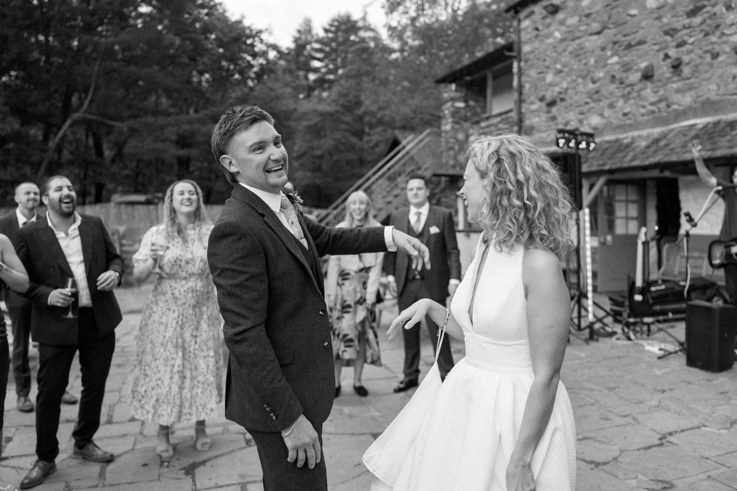 Wedding party walks along a path during an outdoor celebration.