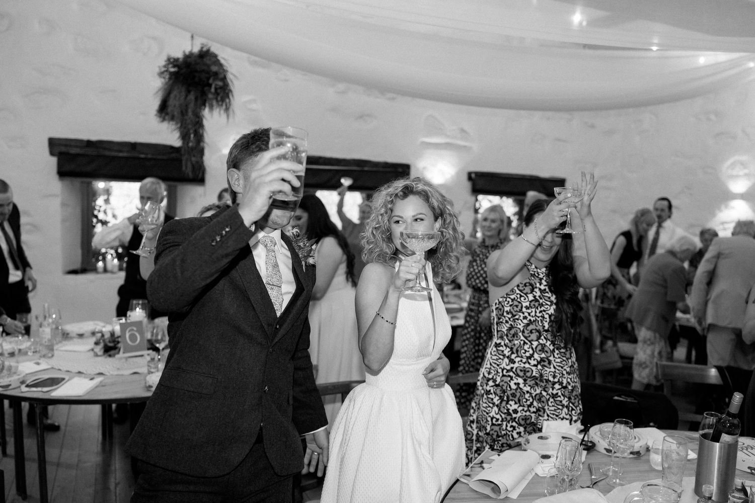 Wedding guests enjoying a lively celebration at an indoor reception venue.
