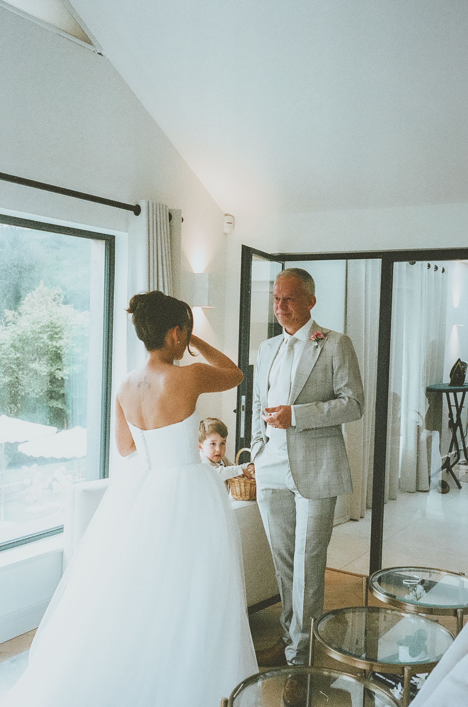 A heartwarming first look moment between people at a bright, modern wedding venue with large windows.