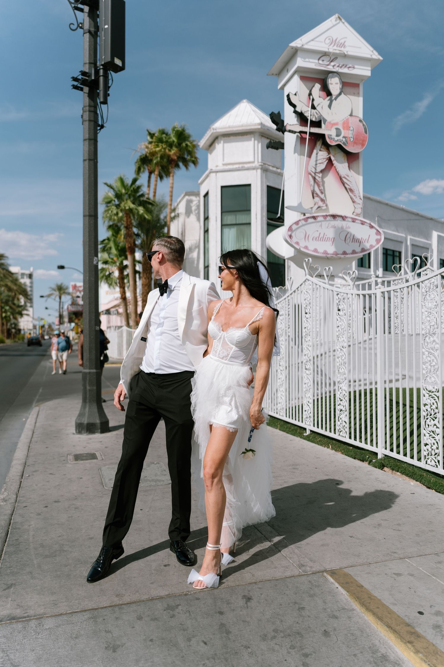 Couple strikes vintage-inspired dance poses outside Las Vegas wedding chapel.