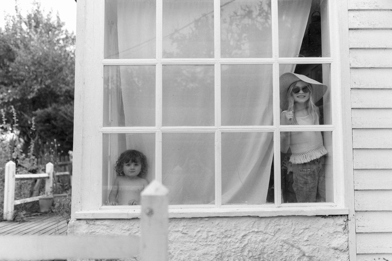 Black and white image of windows on a white house exterior.