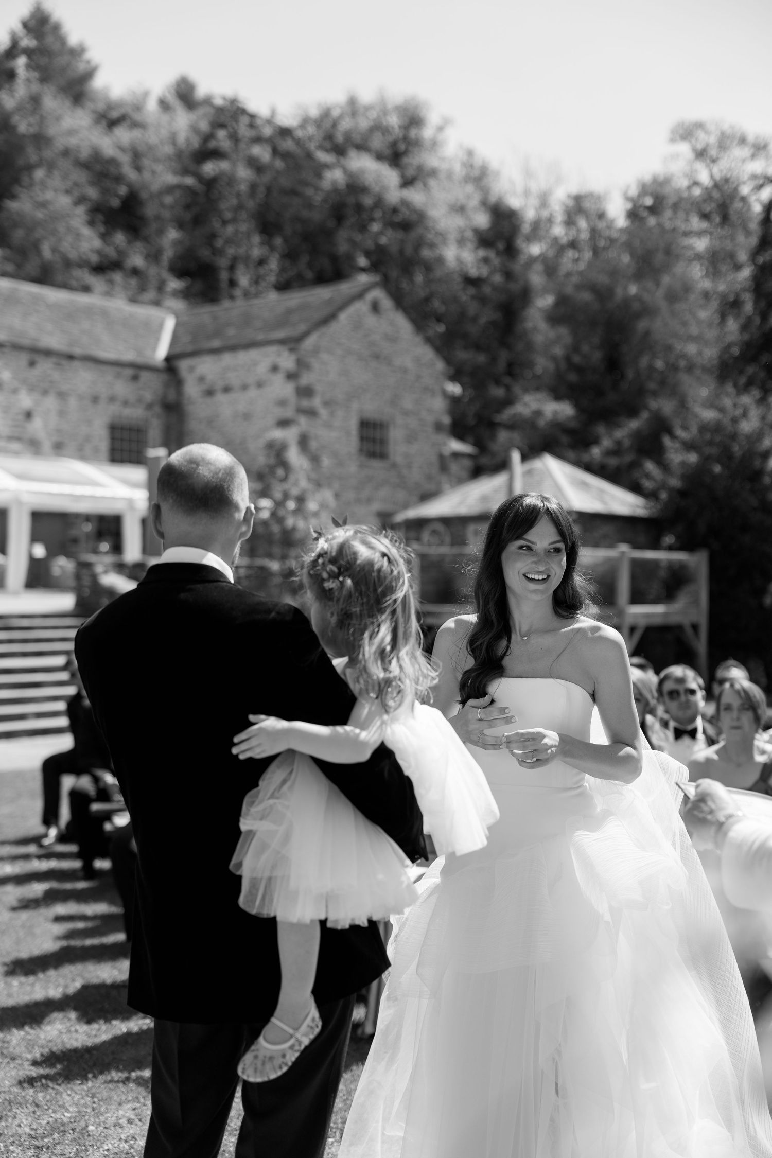 Black and white wedding photos showing couples dancing outdoors near stone buildings.