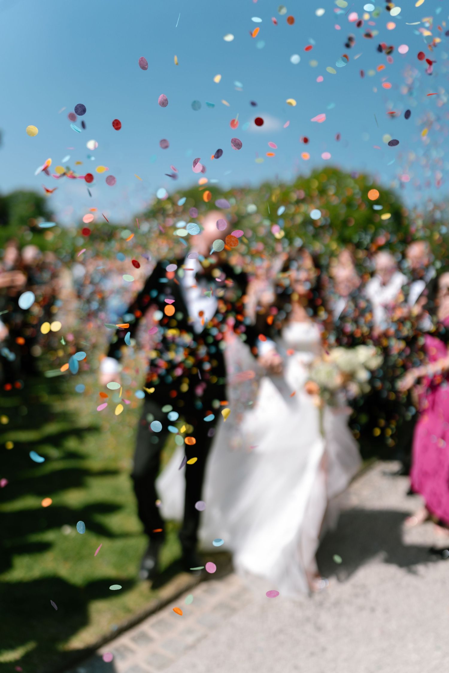 Soft focus shot of wedding celebration with colorful confetti floating through the air.