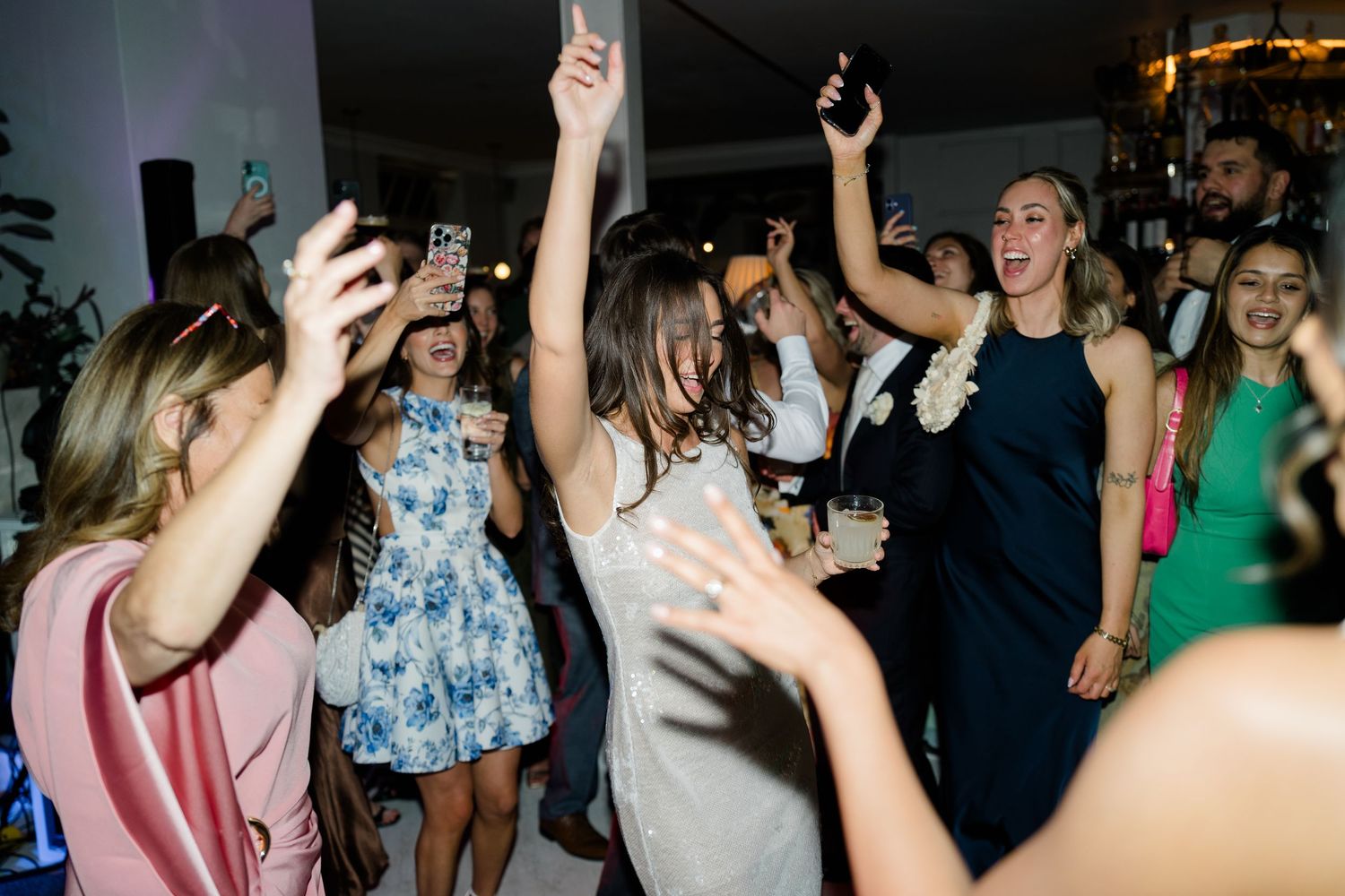 Guests dancing and celebrating energetically on a lively wedding reception dance floor.