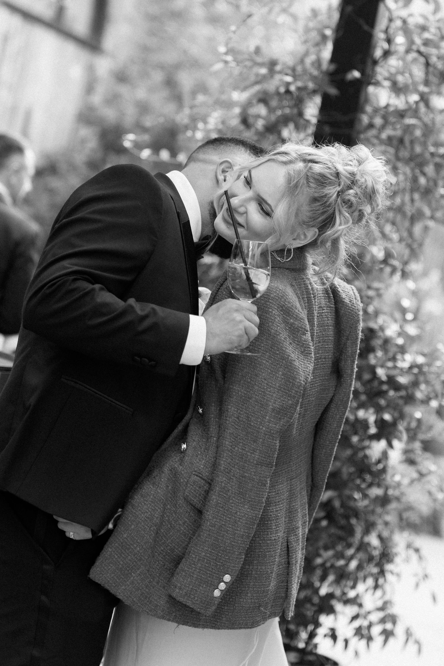 Black and white photo of people in formal attire interacting with a grey jacket.
