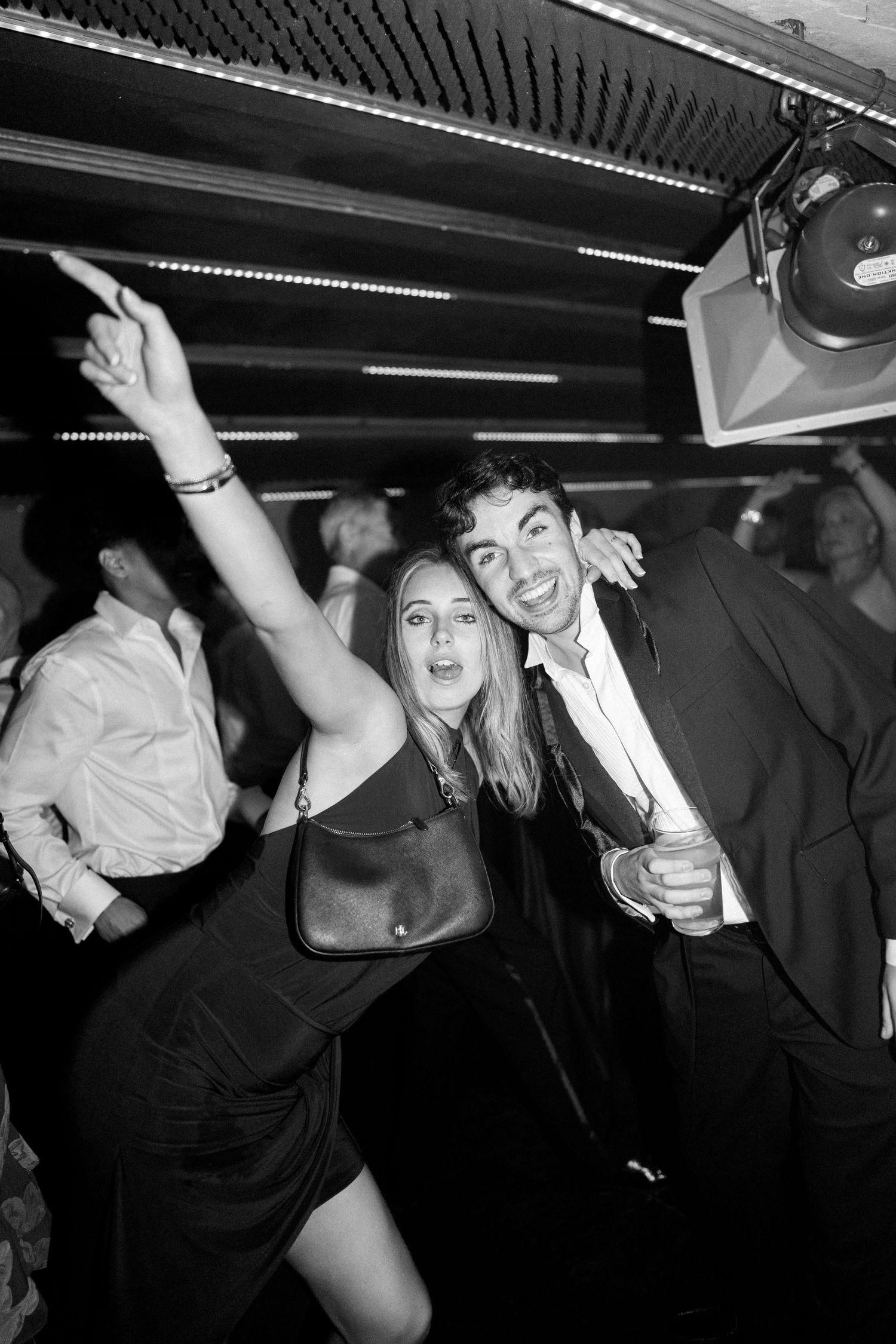 Couple dancing and celebrating at wedding reception party in black and white photo.