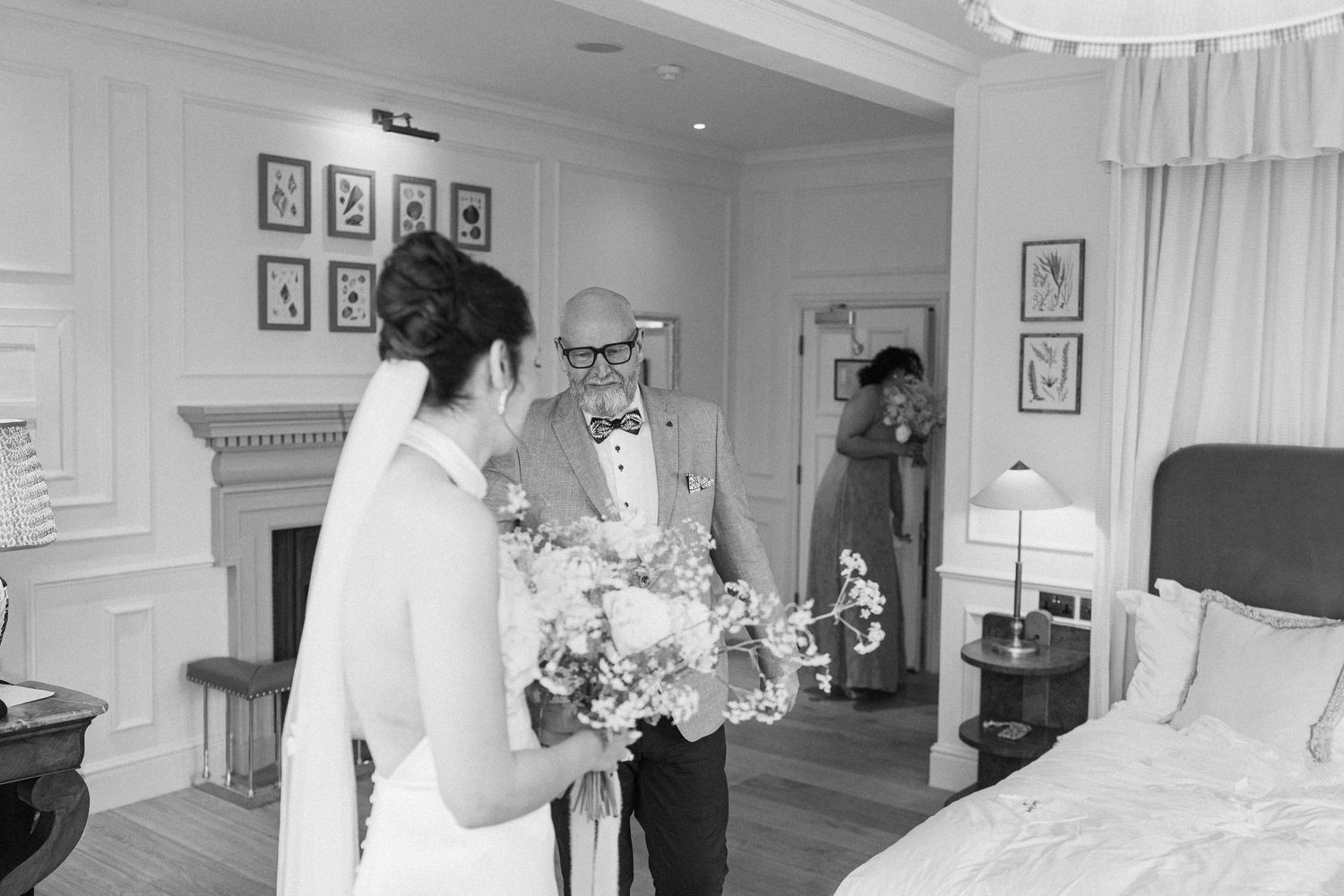 Father seeing bride in wedding dress for the first time in an elegant hotel room.