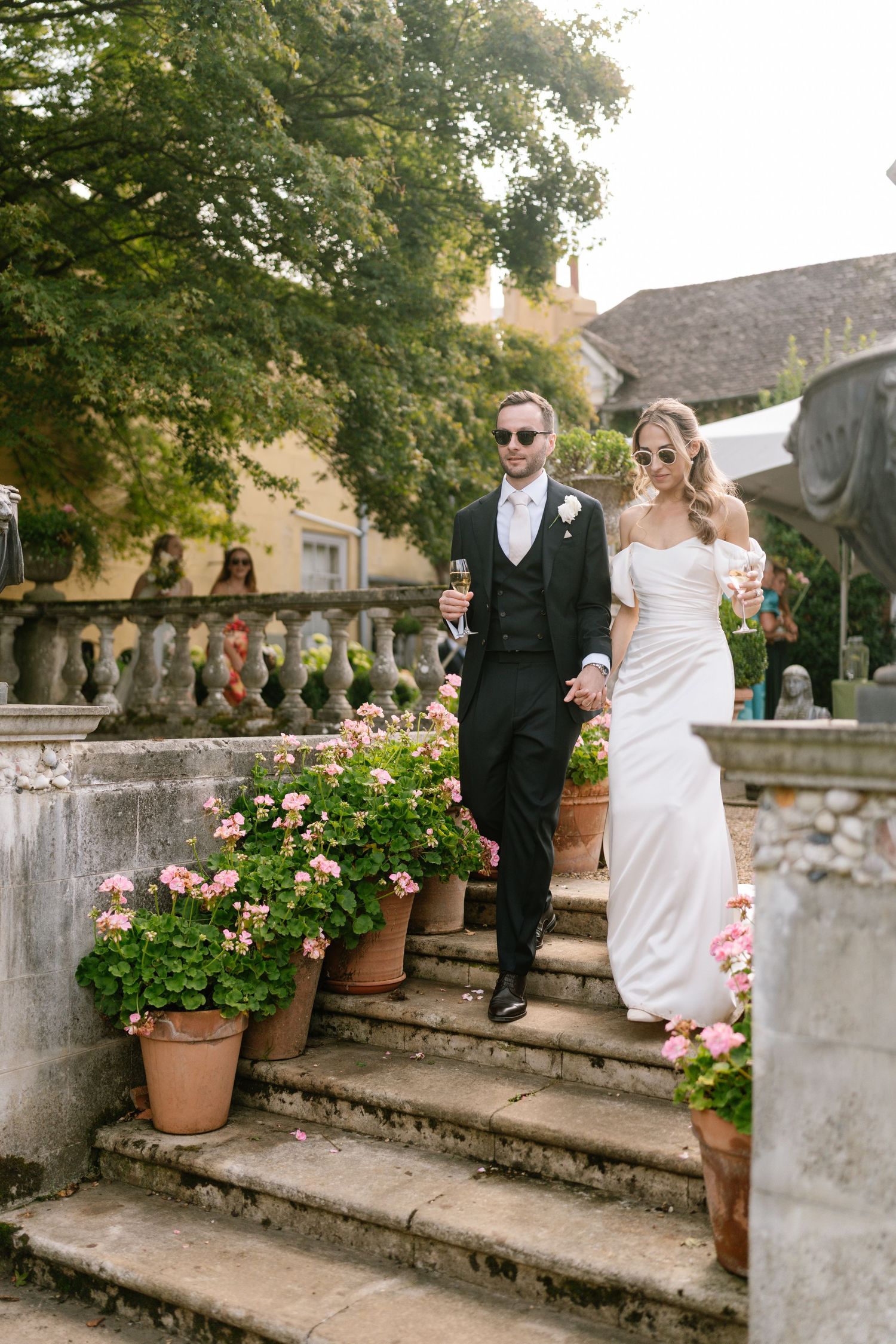Couple ascending stone garden steps decorated with potted flowers.