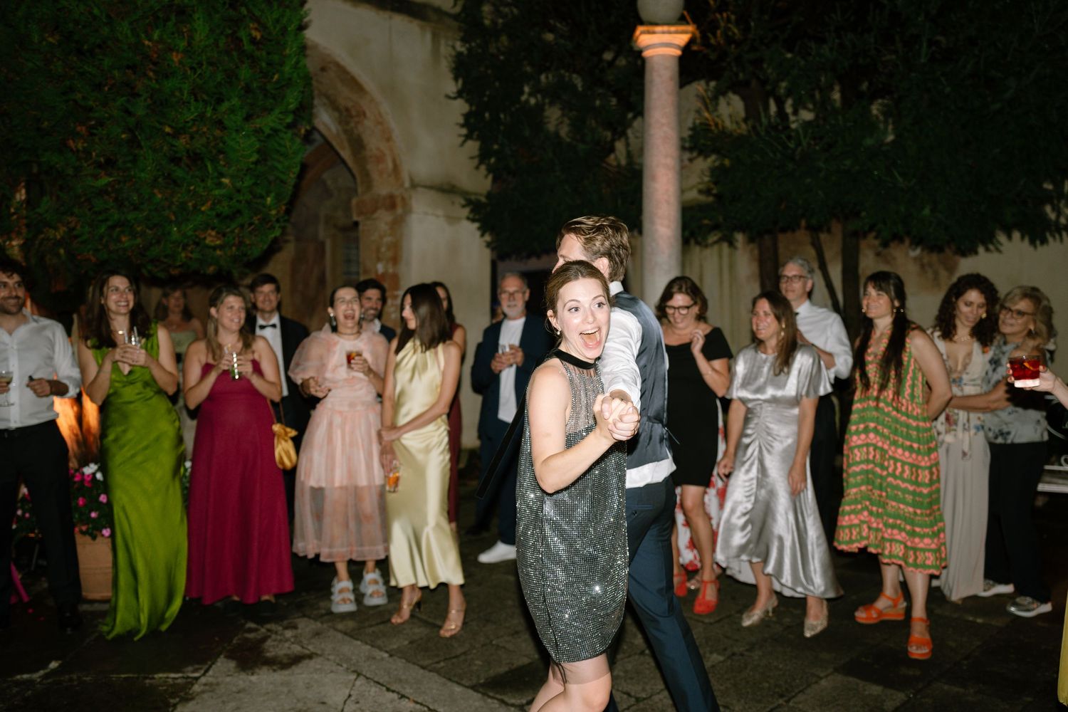 Crowd of party guests mingling and dancing at an outdoor evening event.