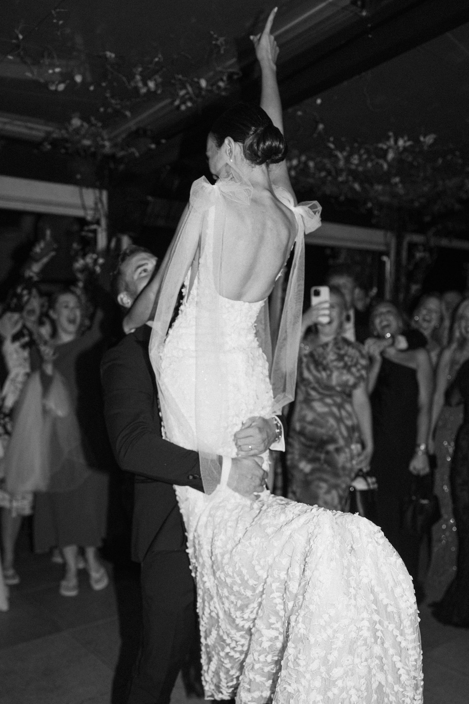 A bride's lace wedding dress flows elegantly as she dances at the reception.