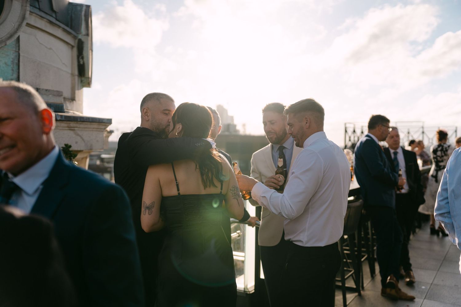 Wedding party enjoying cocktails and conversation during an outdoor reception.