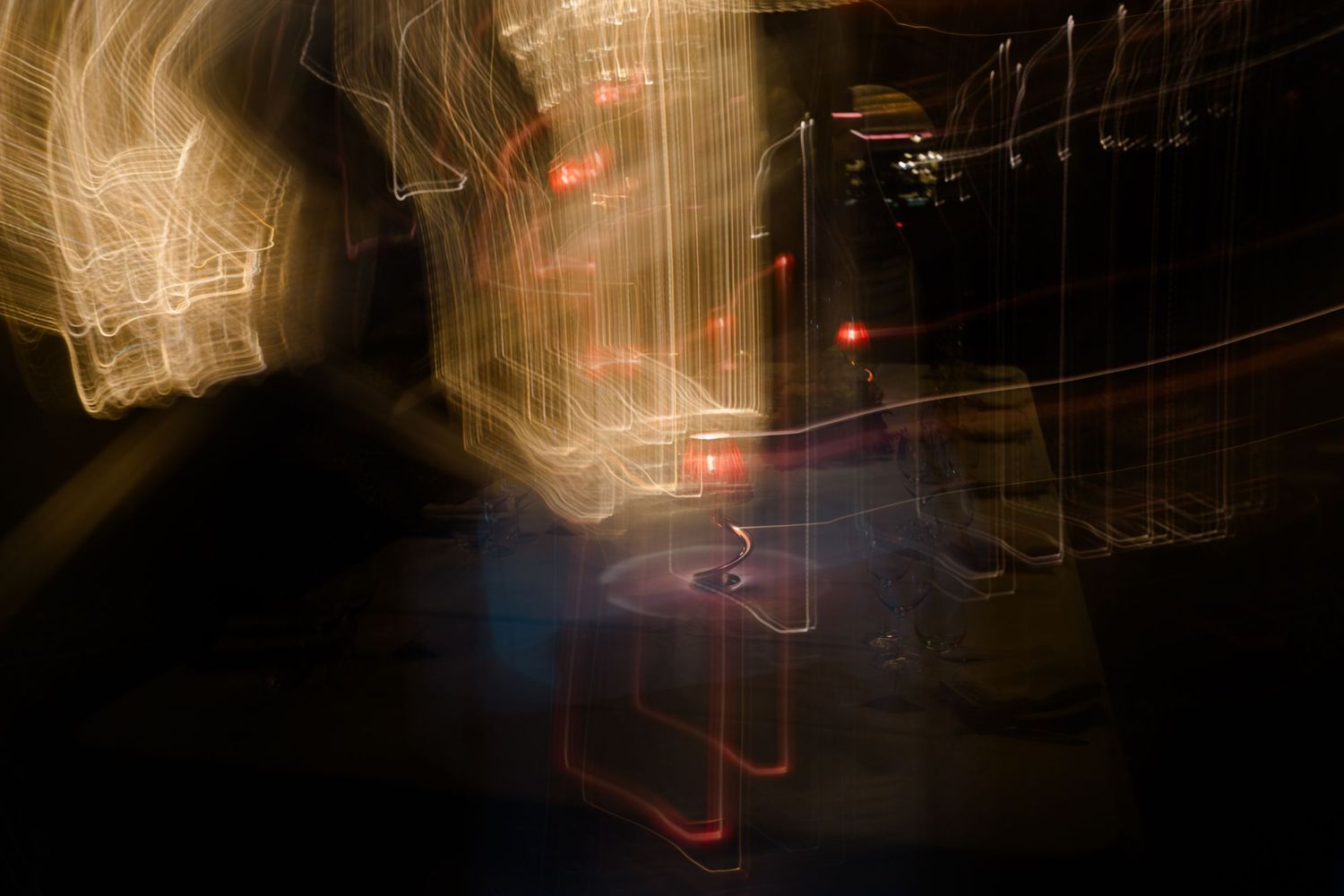 Abstract long exposure wedding photo capturing motion blur of lights in dark venue.