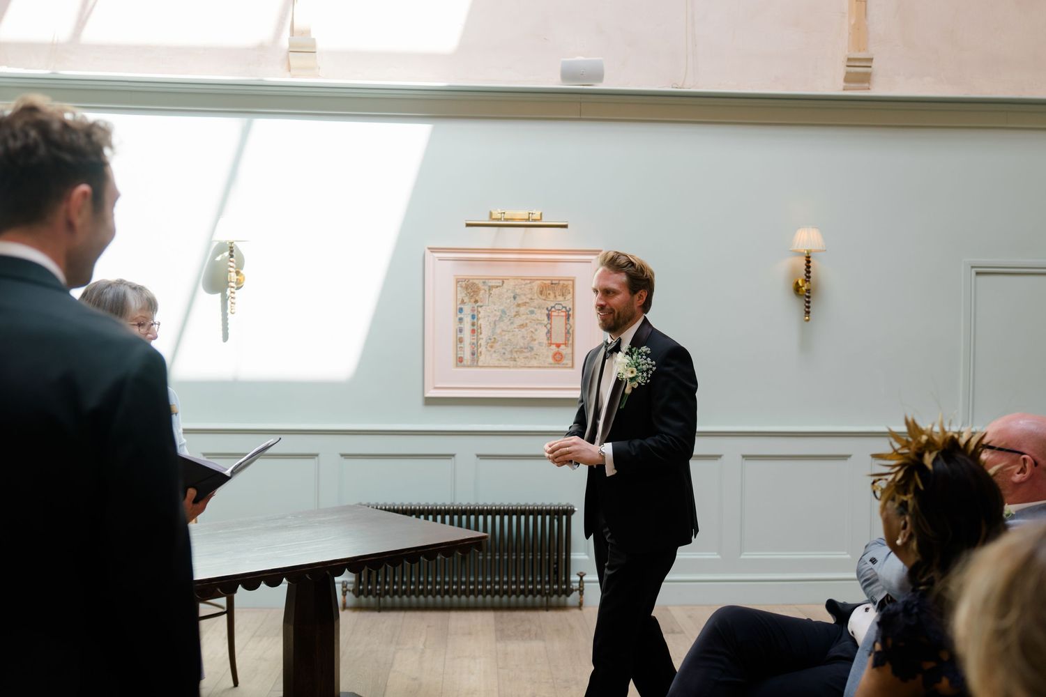 Groomsman delivers heartfelt speech during elegant indoor wedding ceremony.