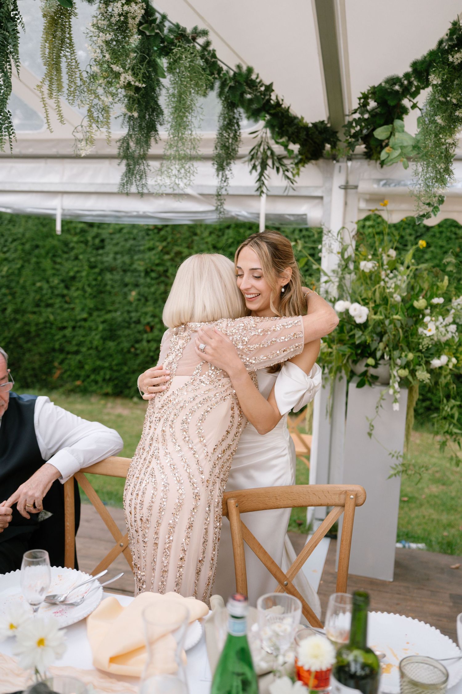 Emotional moment shared between guests during outdoor wedding reception.