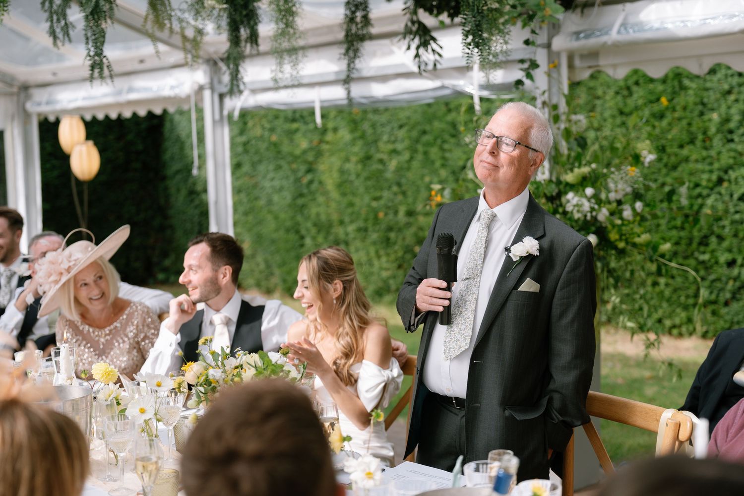 Elegant outdoor wedding reception with greenery and string lights creating a magical atmosphere.