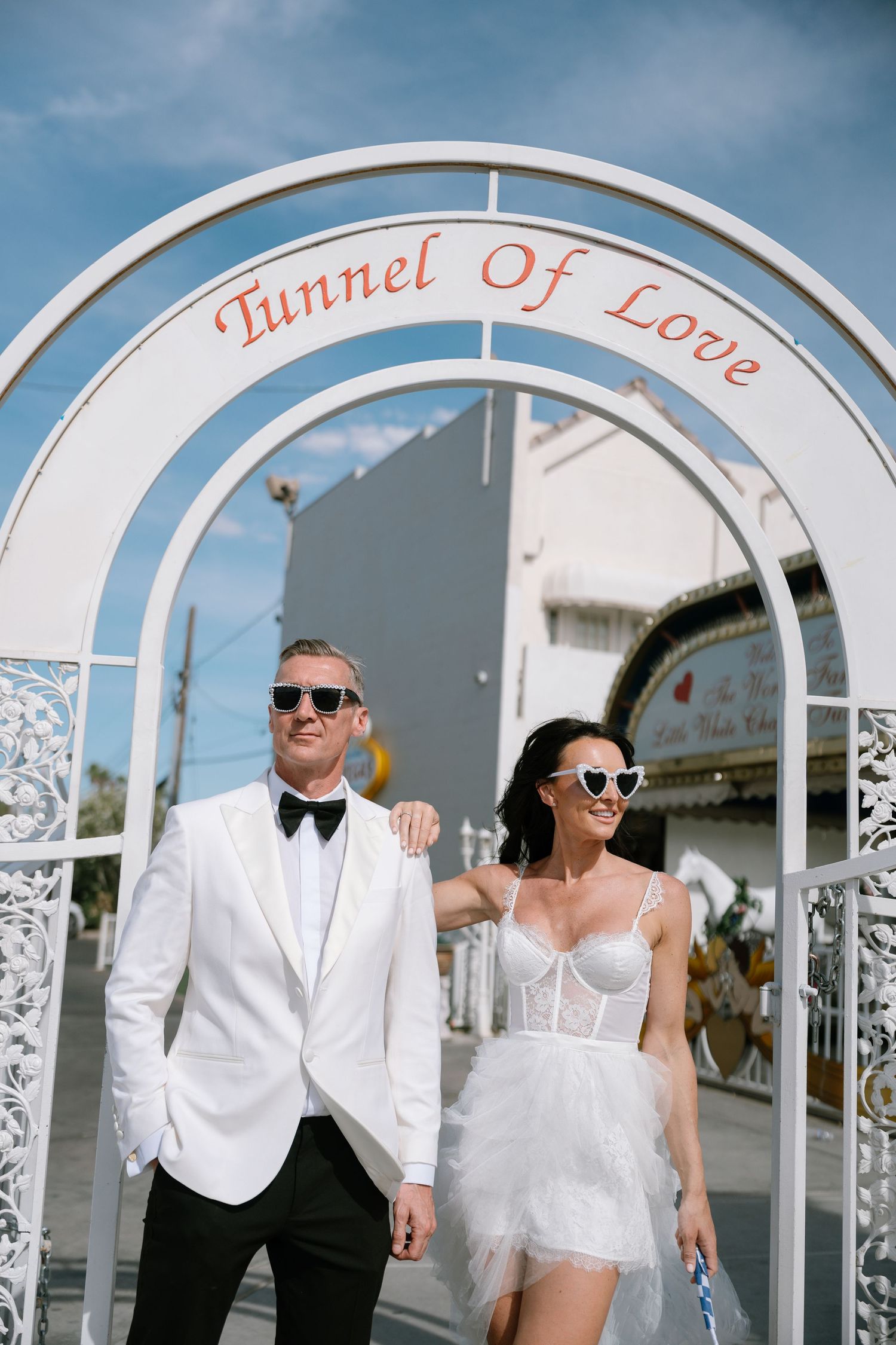 A couple strolls under decorative white arches at a Las Vegas wedding venue.