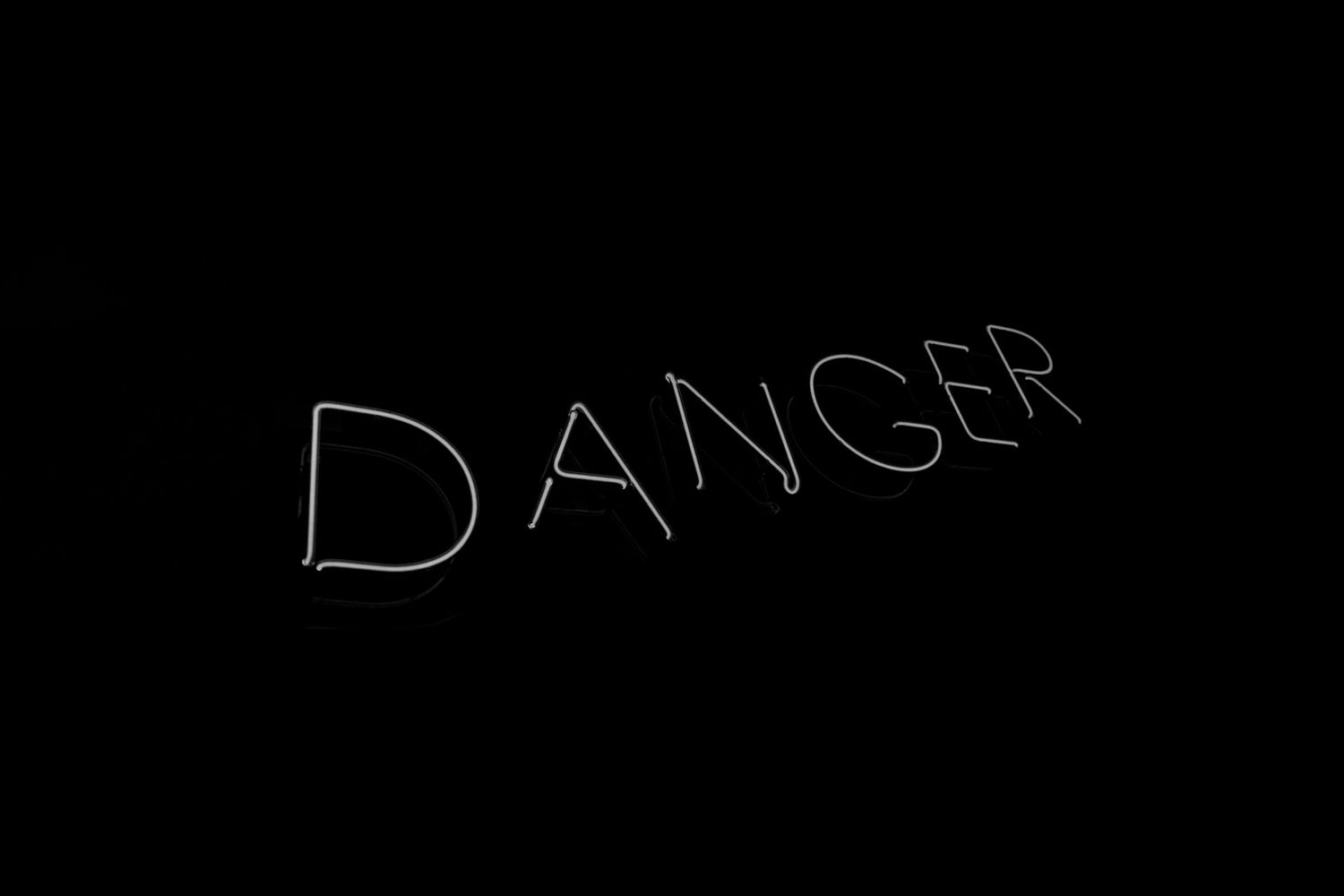The word DANGER written in white chalk lettering on a black background.