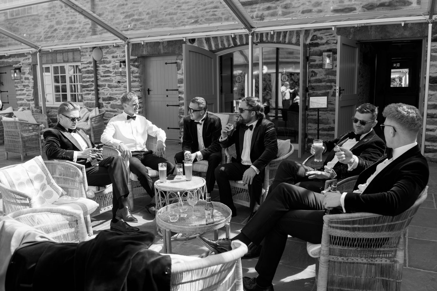 Wedding guests gathered at outdoor reception tables enjoying conversation and drinks.