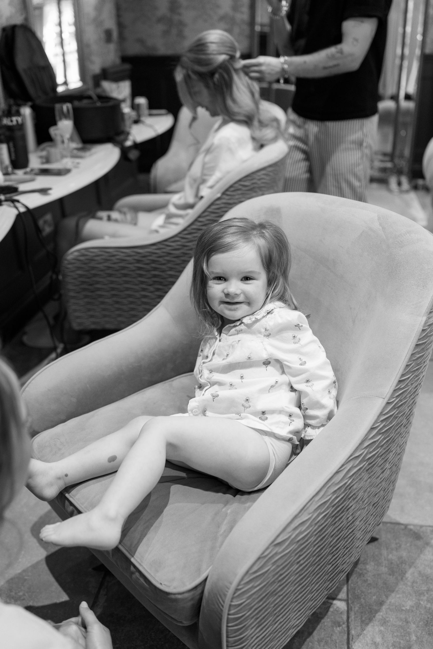 Child relaxing in a textured gray armchair.