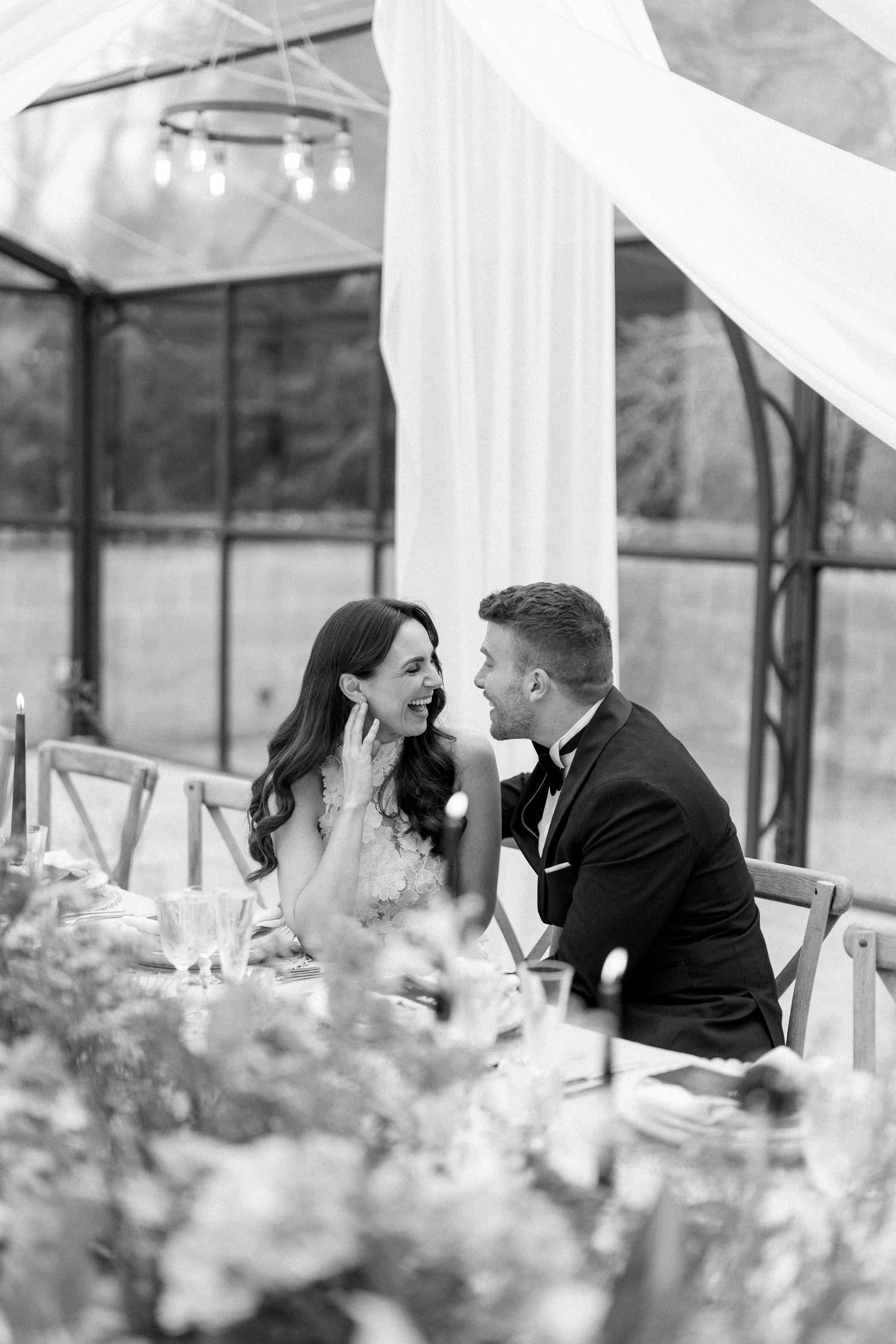 Romantic moment between couple at elegant outdoor wedding reception.