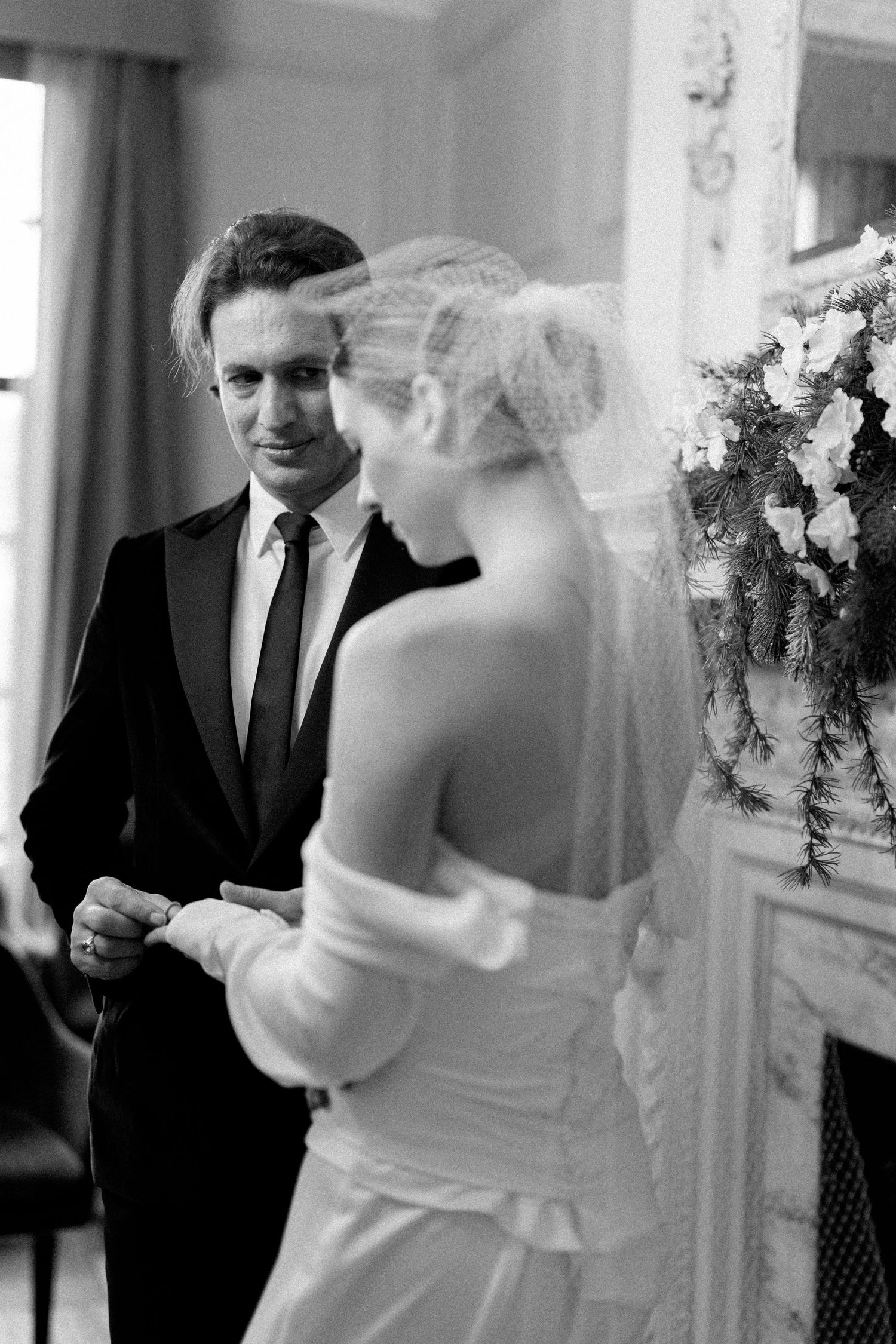 A candid wedding sequence showing interactions in an elegant white interior space.