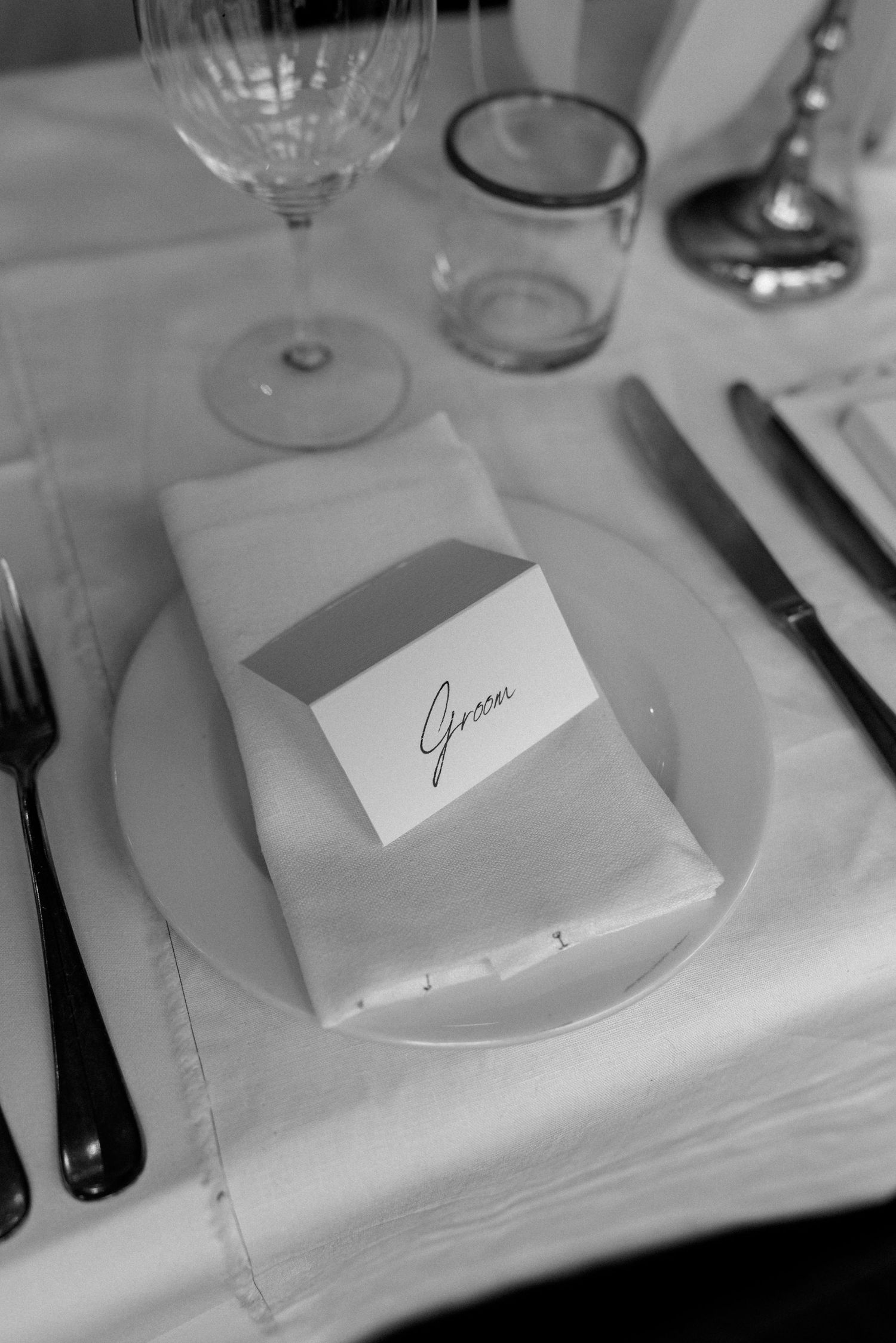 Elegant place setting with wine glass and name card at formal dinner.