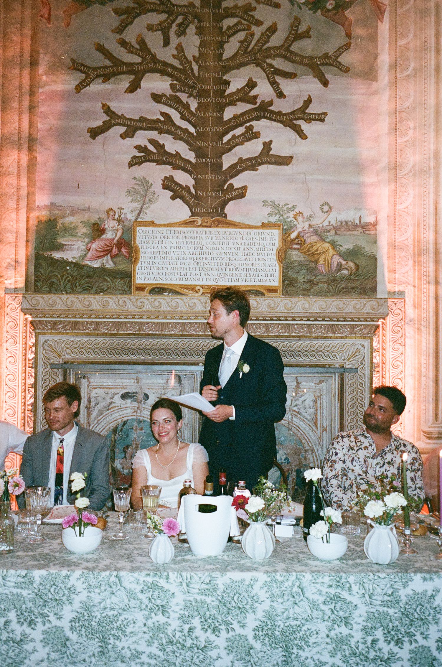 A formal dining table decorated with white floral centerpieces and crystal displays at an elegant event reception.