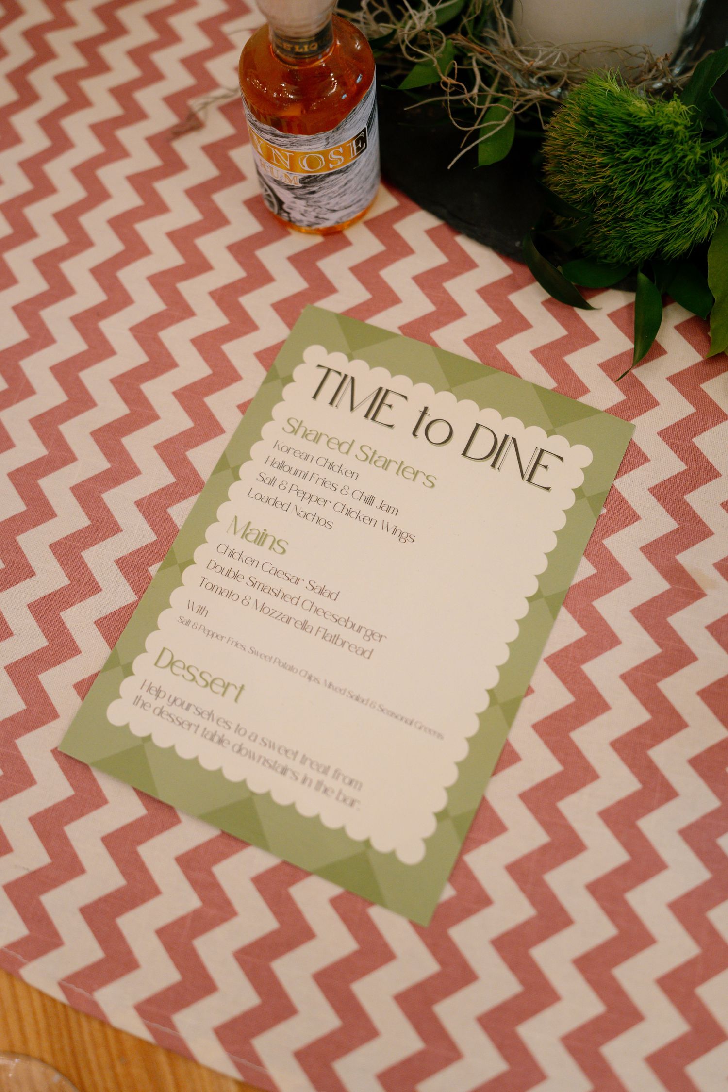 Pink chevron patterned tablecloth with menu cards labeled 'Time to Dine' in green scalloped frames.