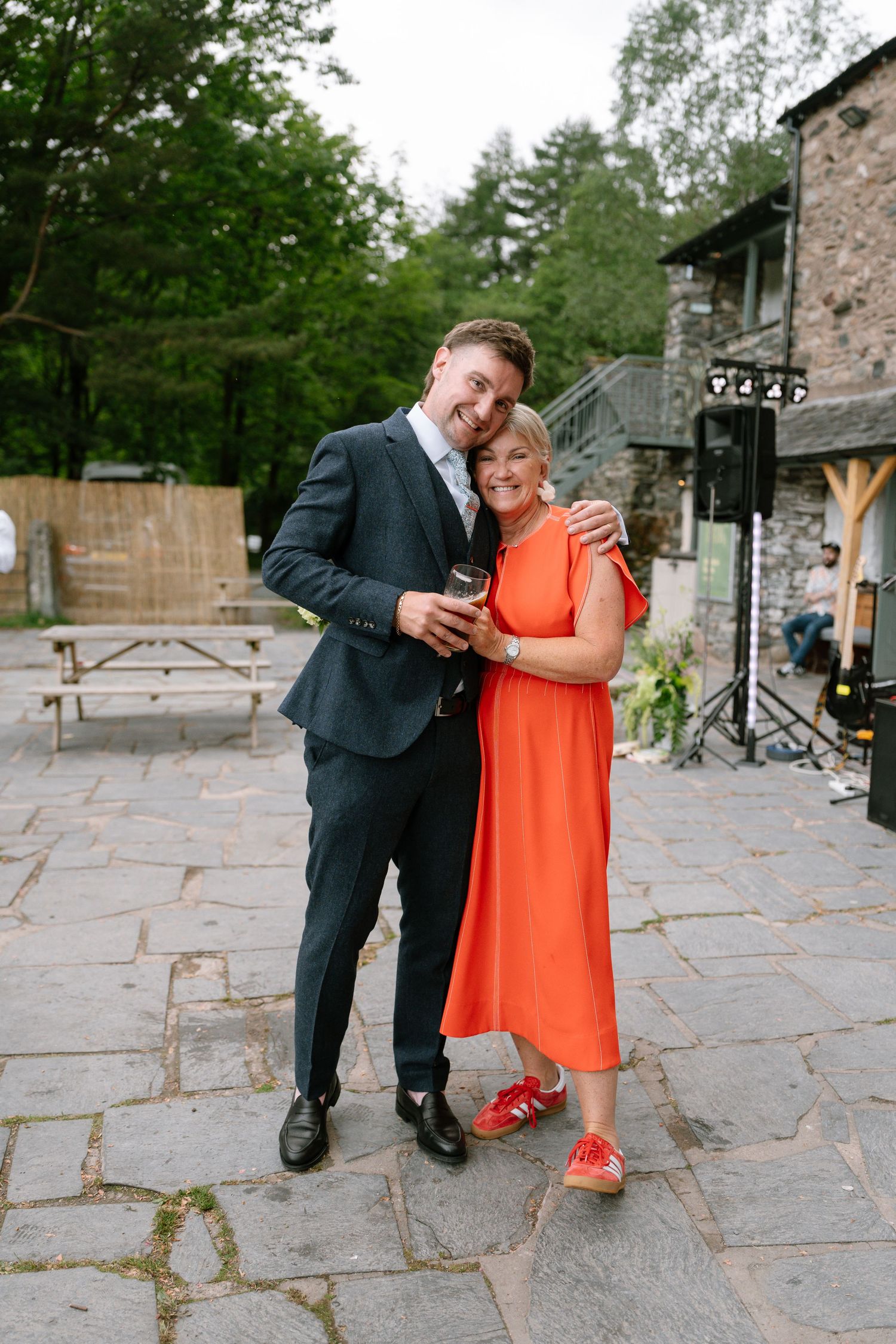 Wedding couple shares an intimate moment on stone patio during reception.
