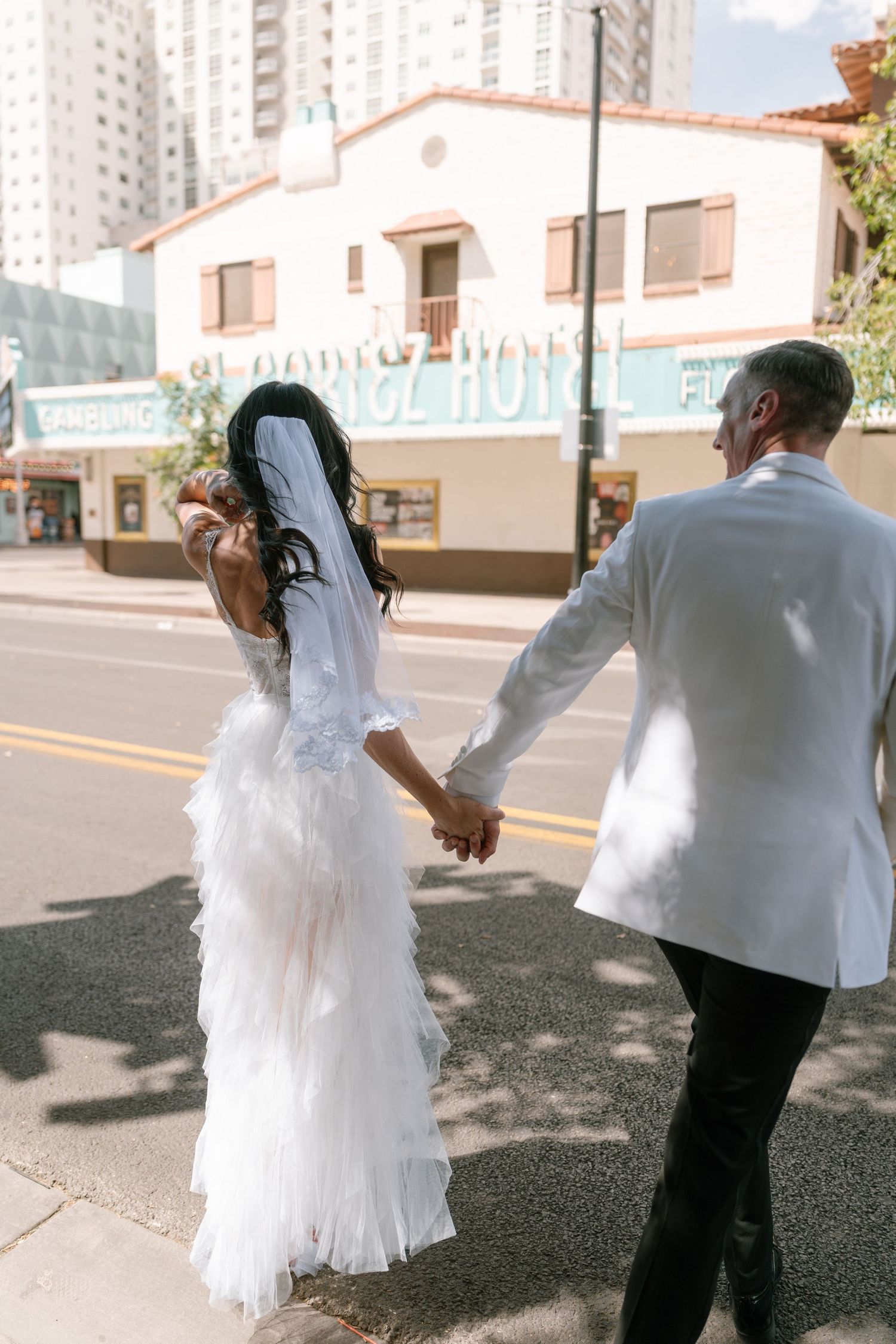 A playful wedding photoshoot sequence showing movement and dance on an urban street.