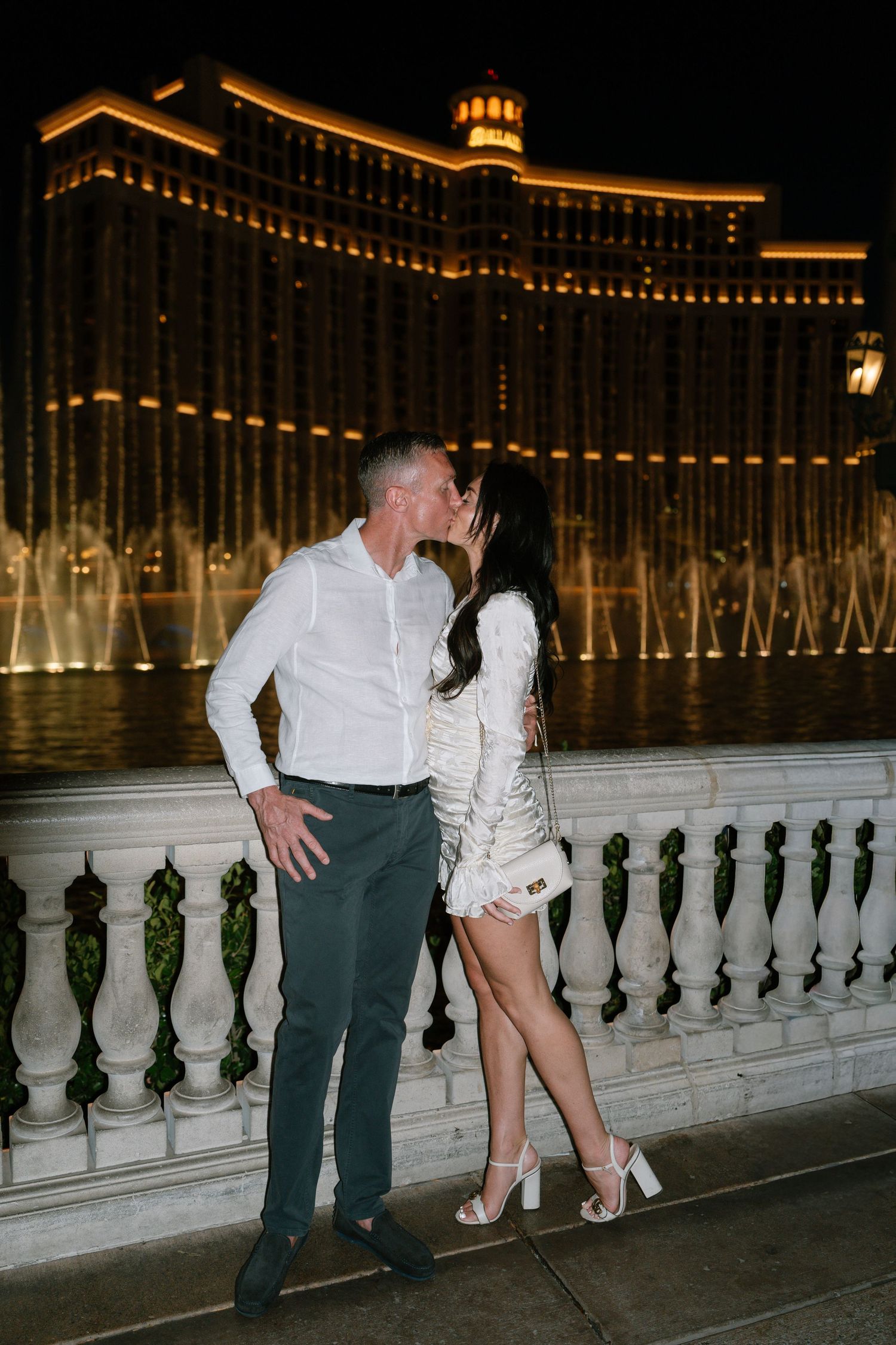 A romantic moment between a couple at the Bellagio fountains in Las Vegas at night.