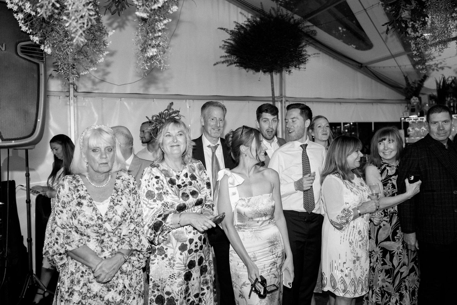 Wedding reception guests celebrating in a decorated indoor venue.