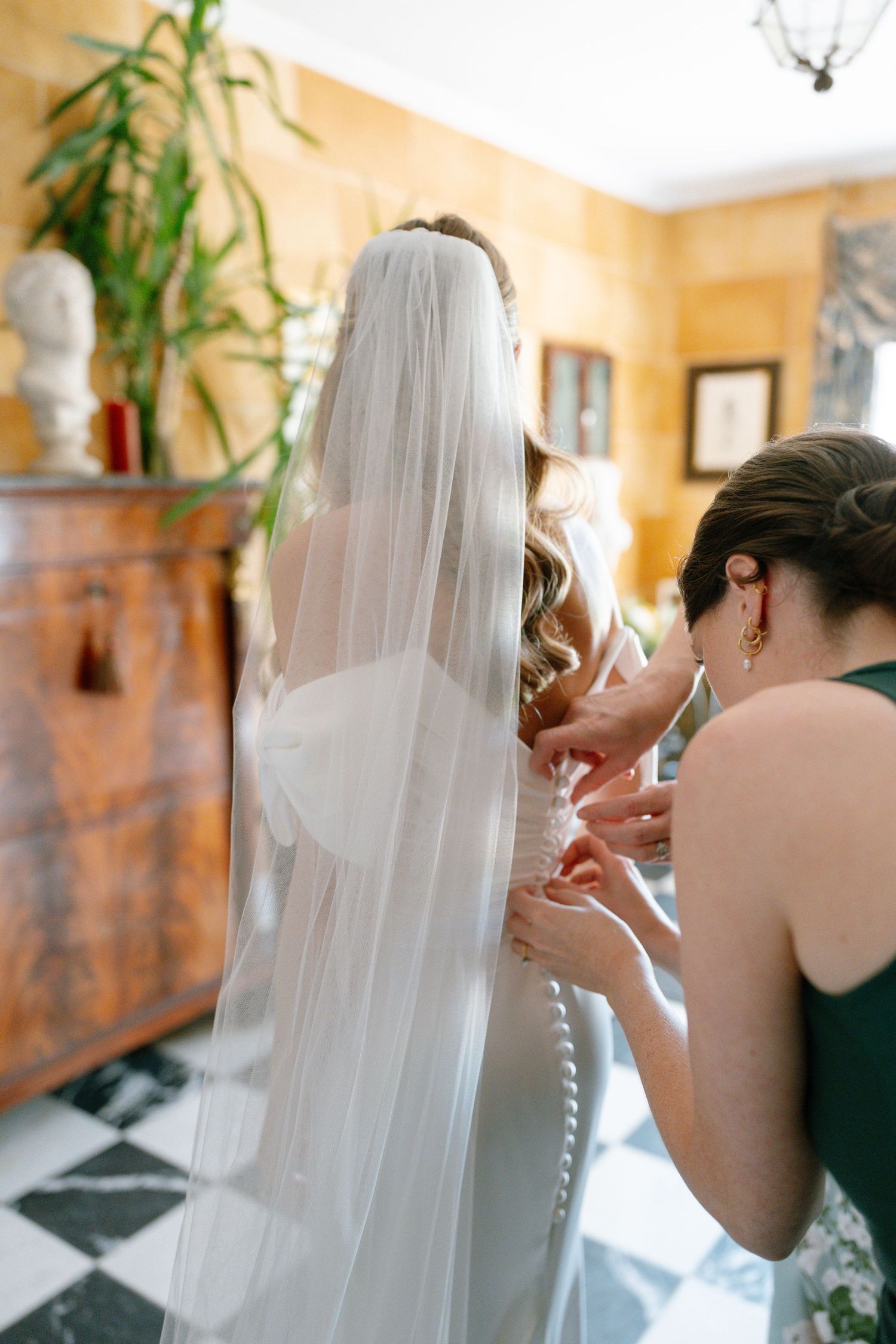 A flowing white veil being adjusted during wedding preparations.