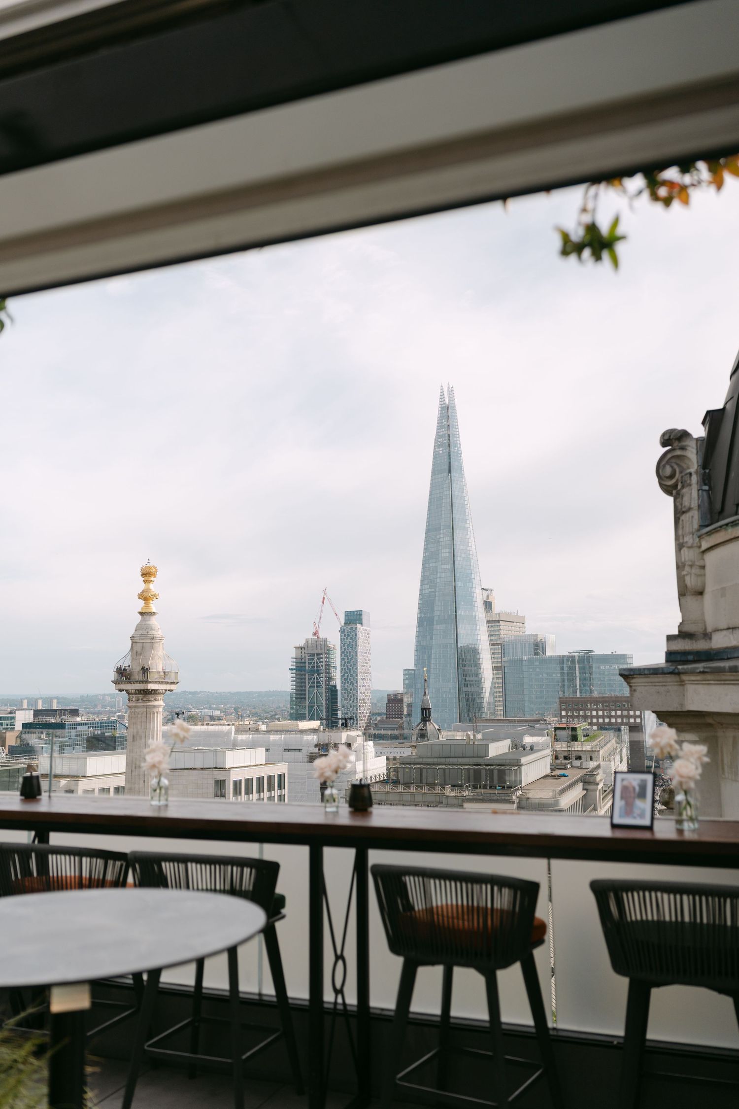 London skyline view with The Shard building from a rooftop restaurant terrace.