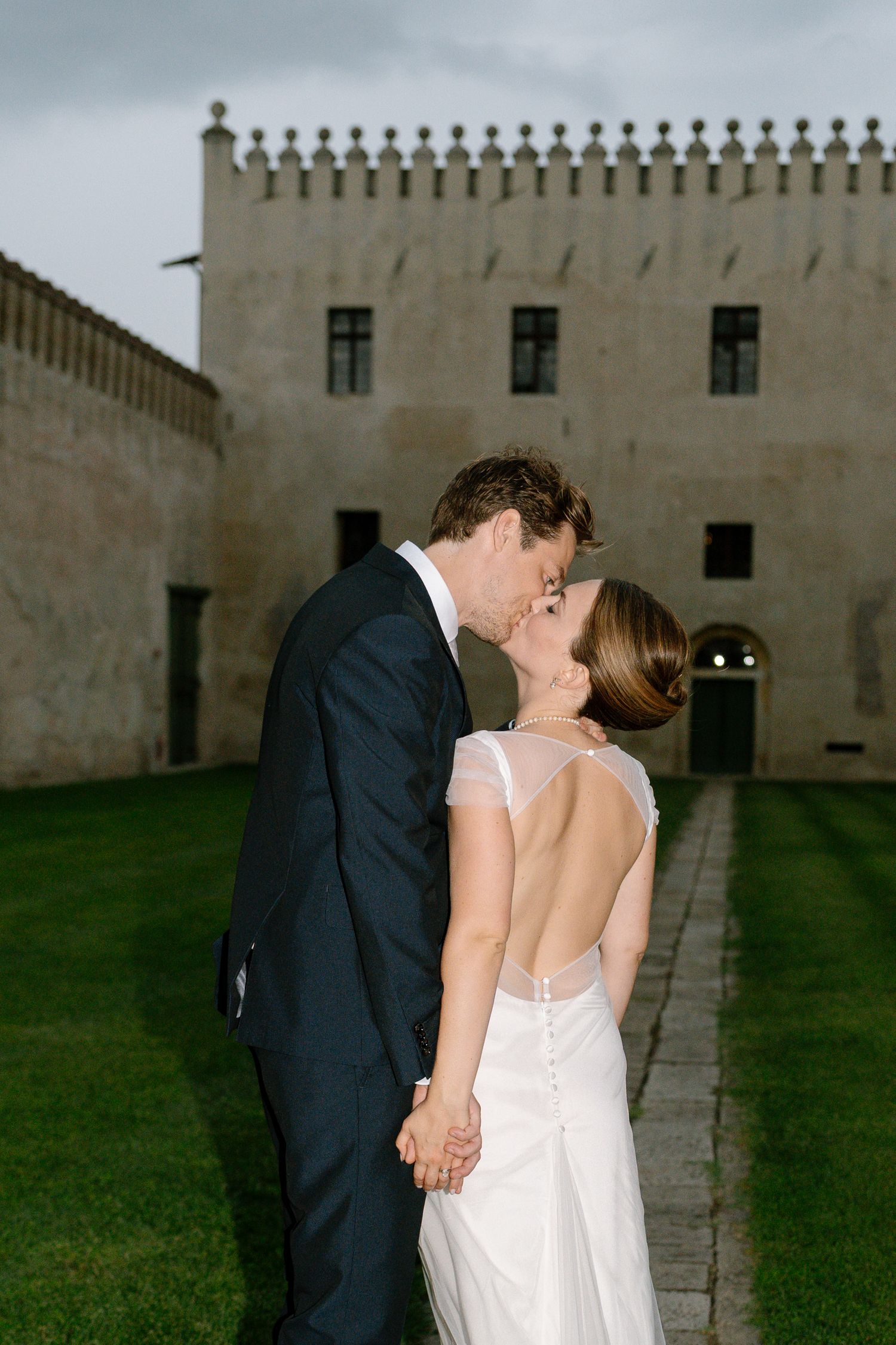 Romantic moment between newlyweds on the lawn of a historic estate.