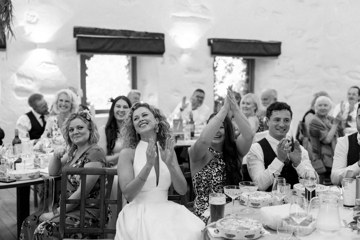 Wedding guests celebrate and raise their hands during a reception party.