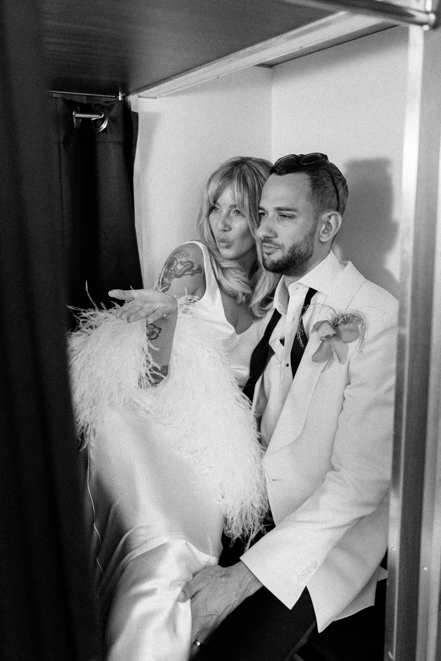 Stylish couple posing in black and white photos with feather details.