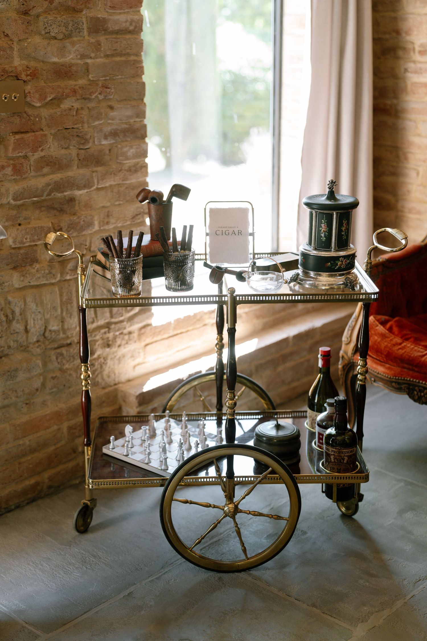A vintage bicycle rests against a brick wall near sunlit windows in a rustic interior setting.