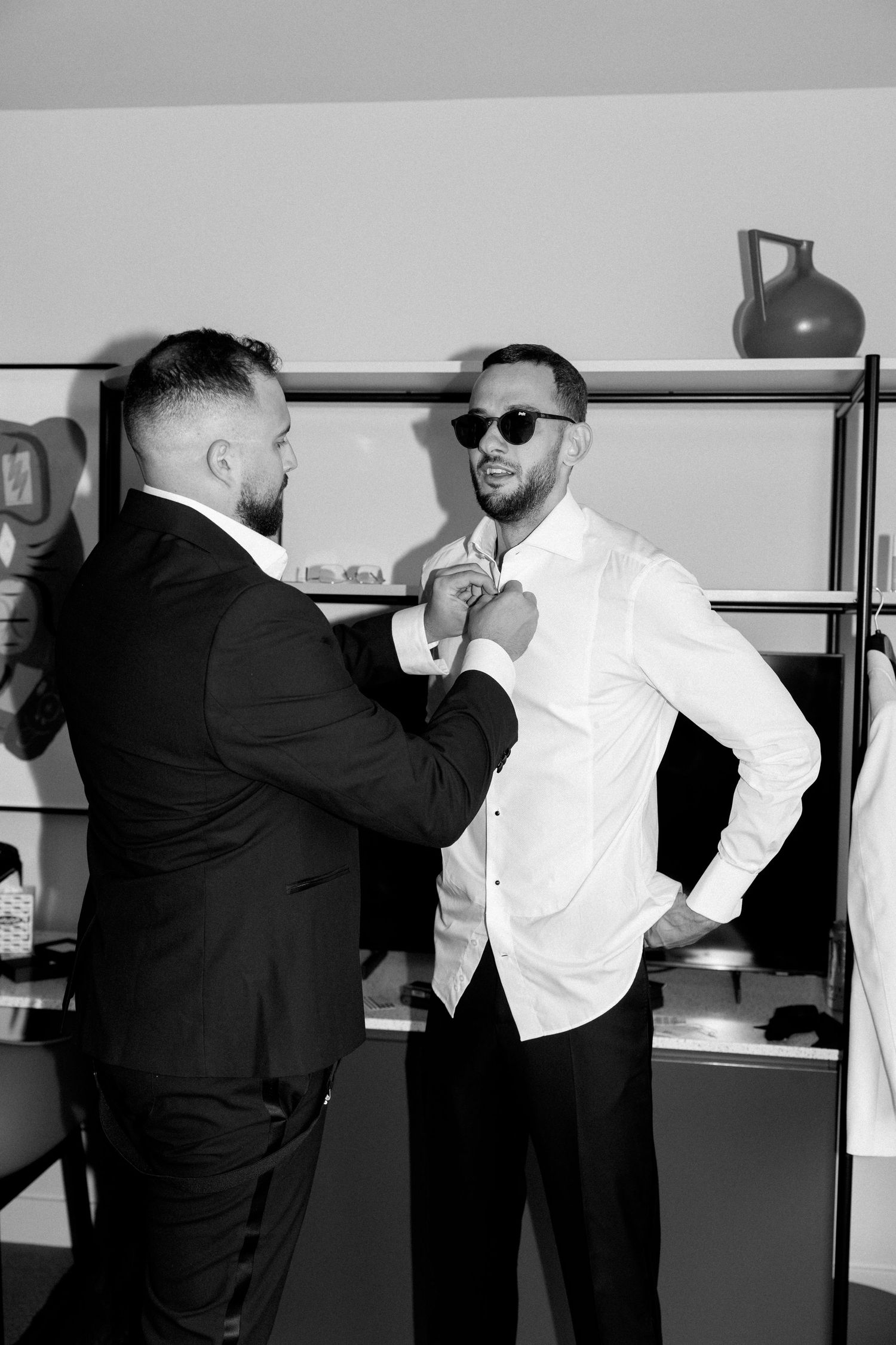 Black and white photos of groomsmen playfully posing and interacting before the ceremony.
