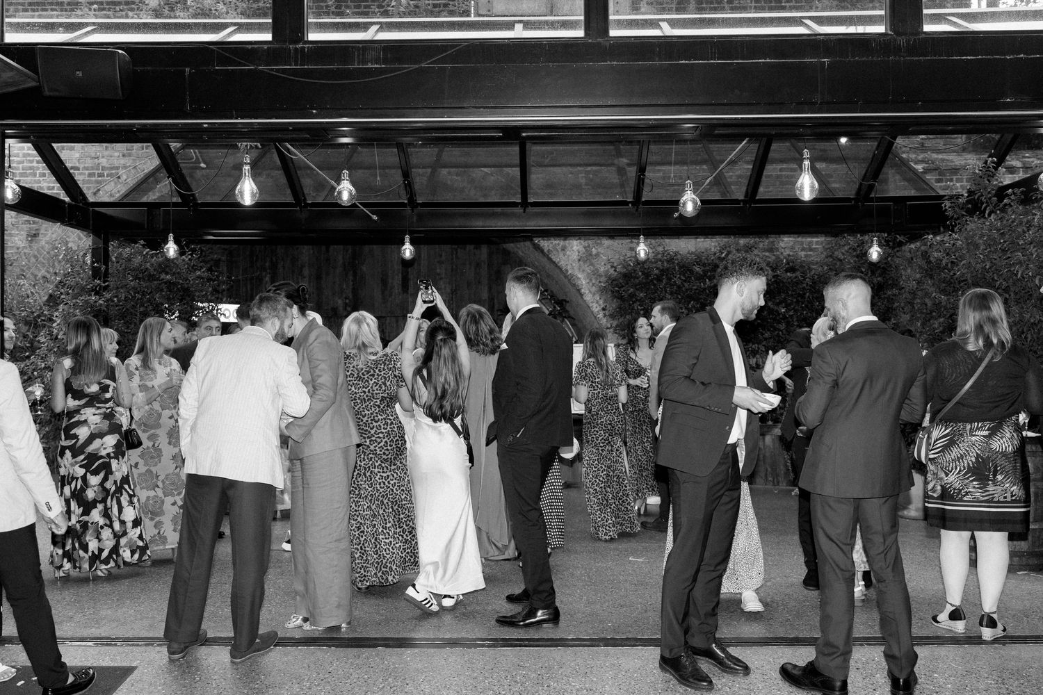 Wide shot of wedding guests mingling during an evening reception.