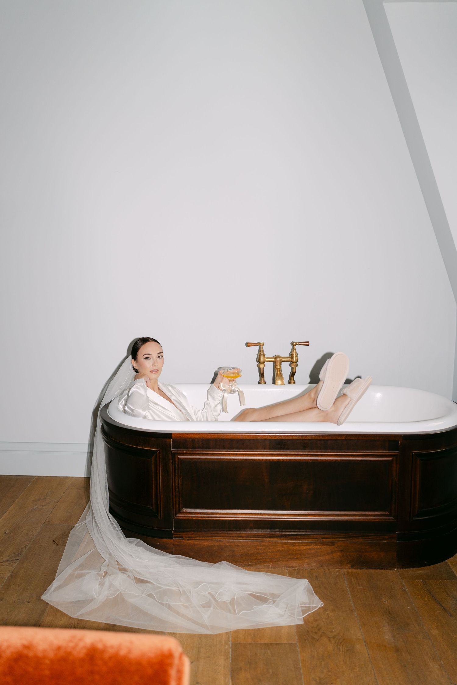 Person enjoying luxurious bath in vintage-style tub with brass fixtures.