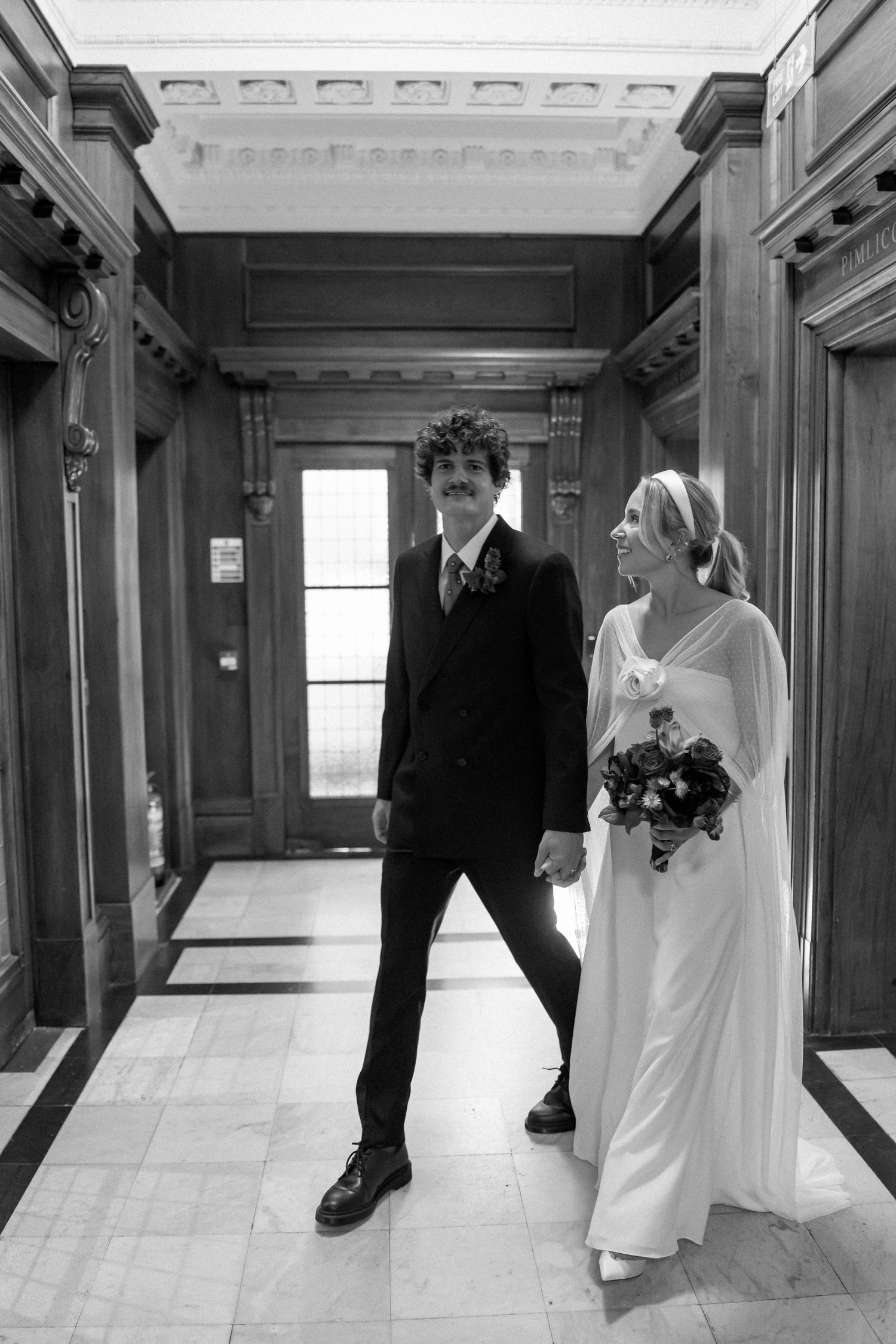 Artistic black and white wedding photos showing couple walking through an elegant hallway.