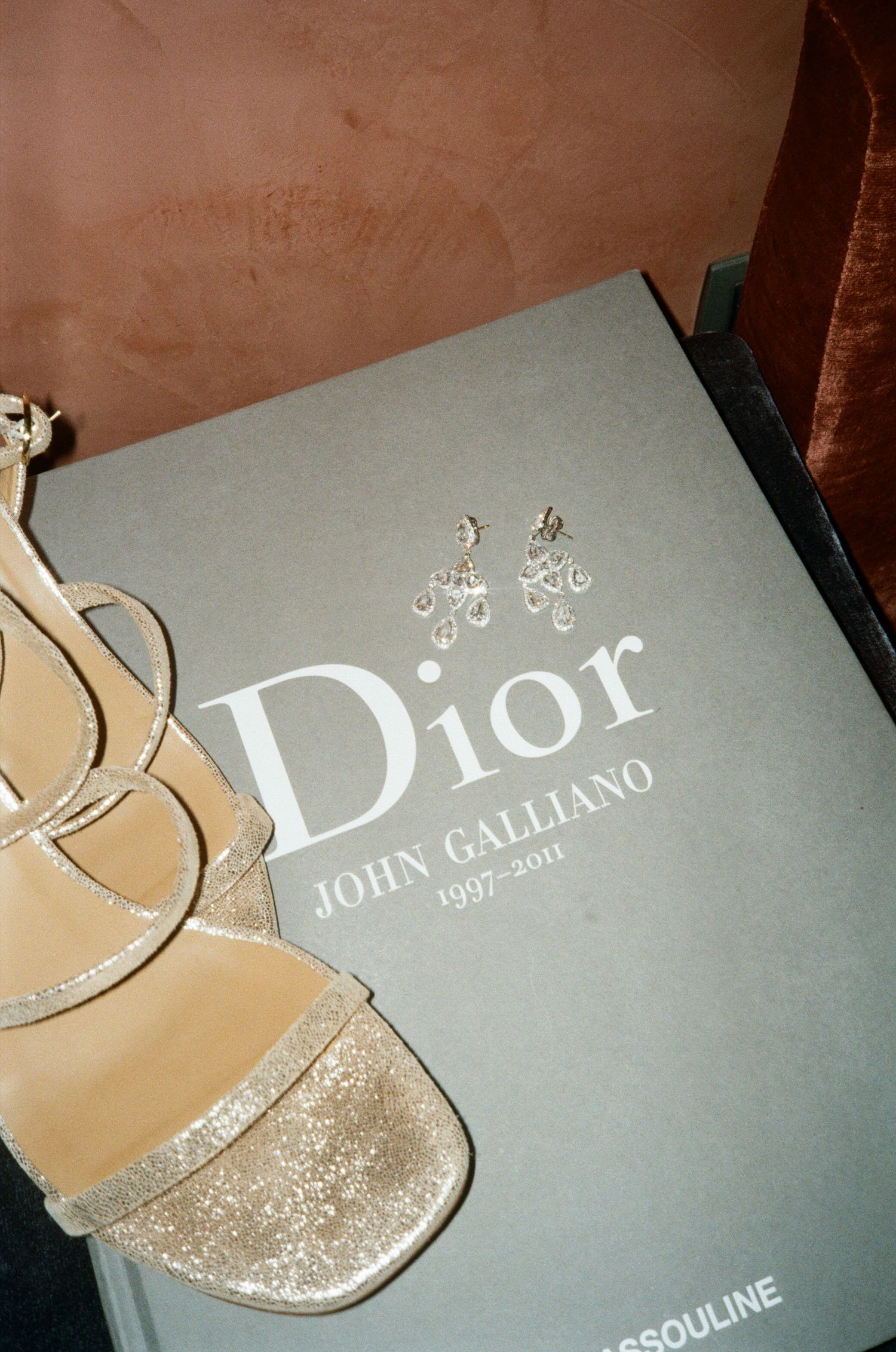 A close-up shot of a Dior fashion book or catalog cover with gold accents.