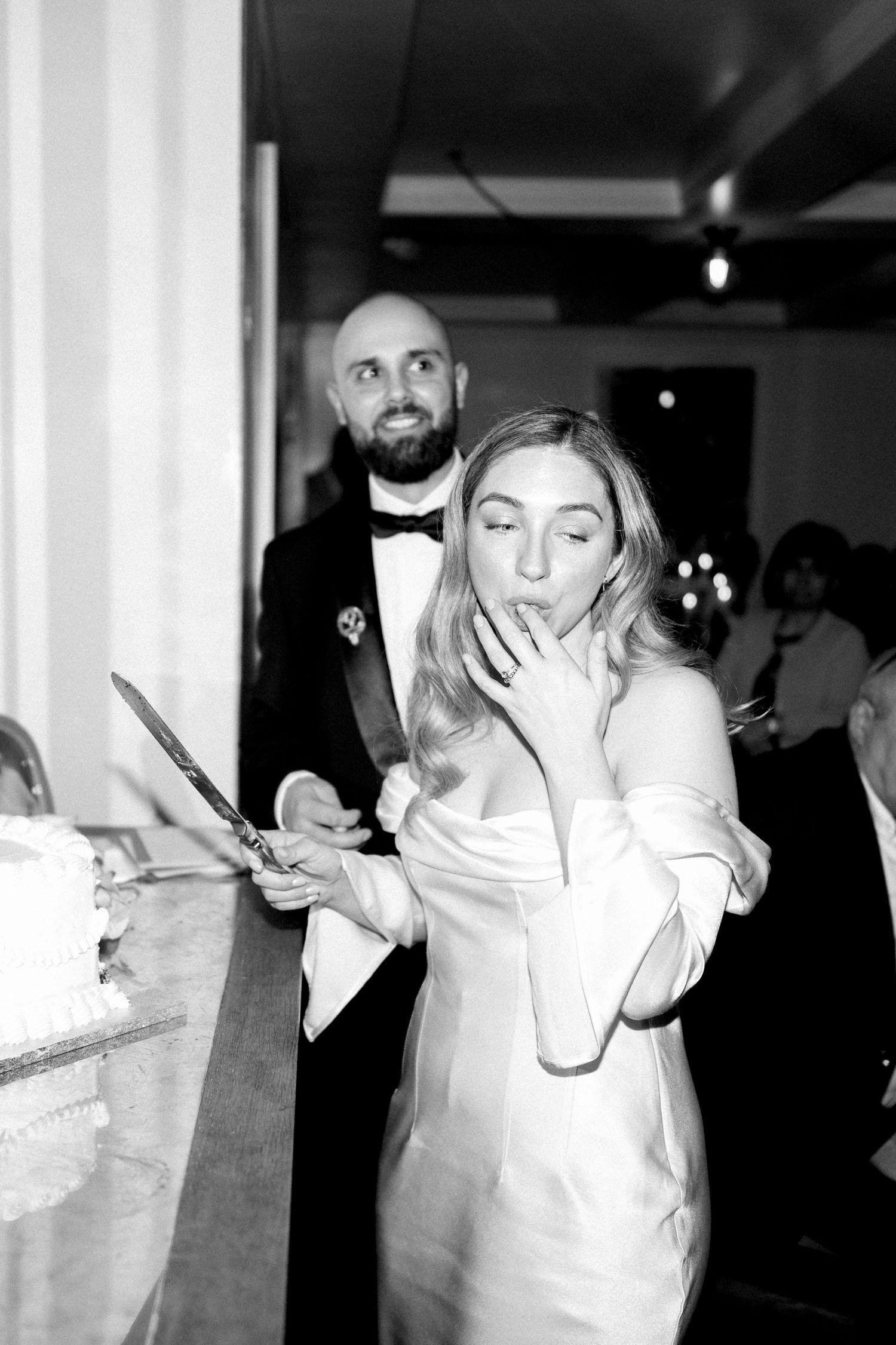 Candid moment of couple at wedding reception in black and white photography.