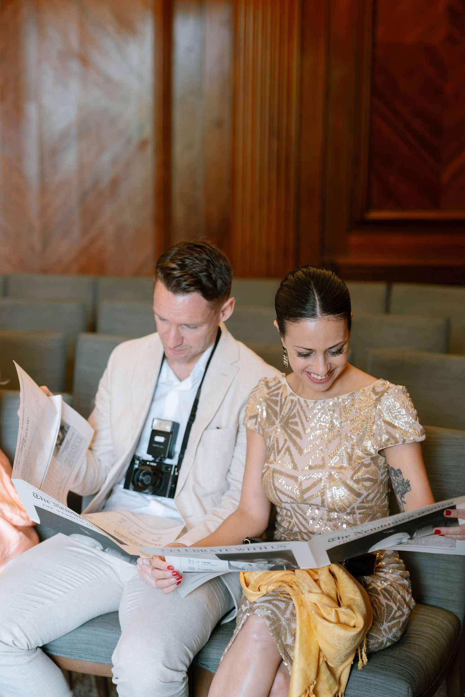 Wedding party reviewing documents together on grey couch.