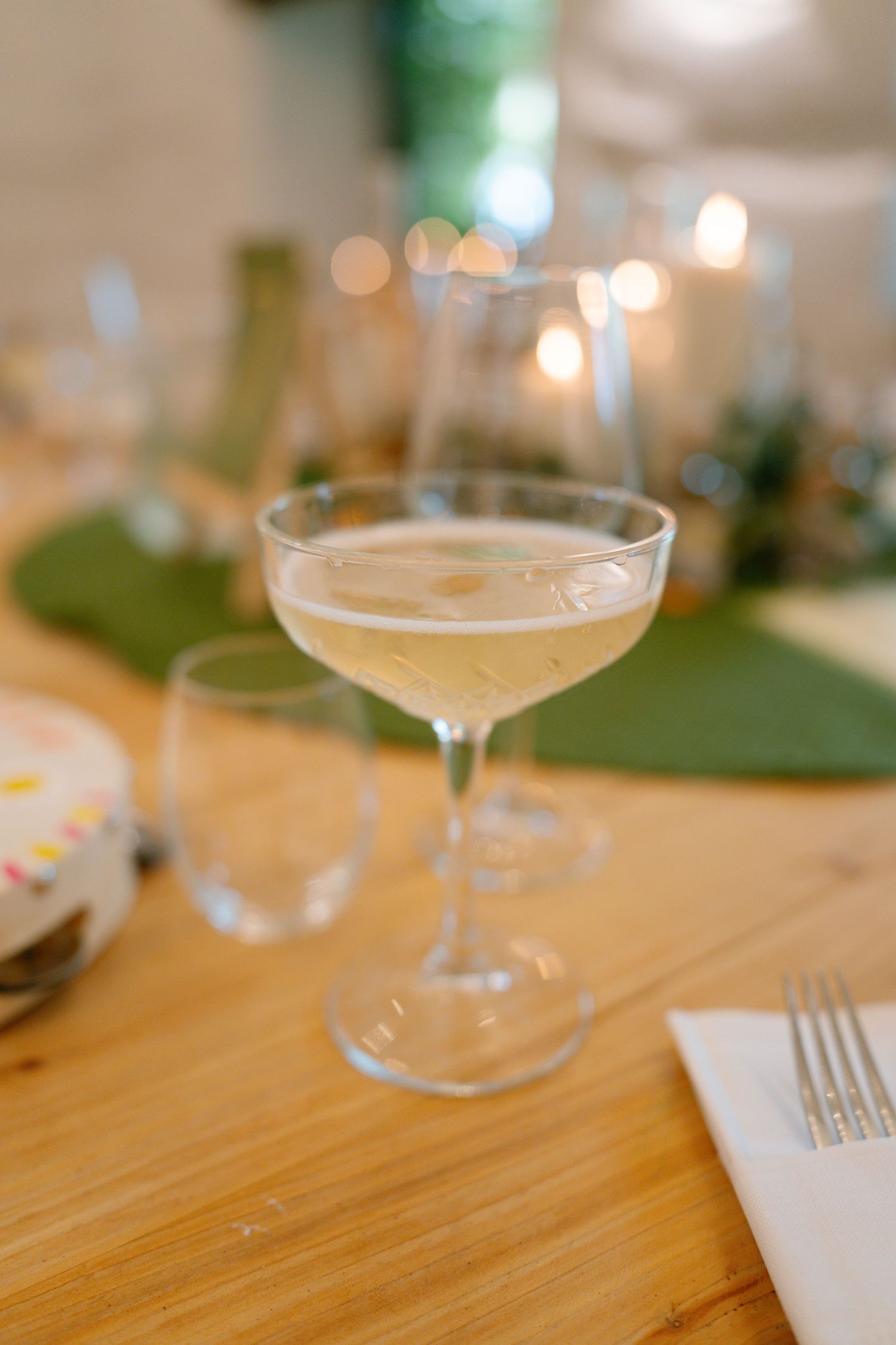 Elegant cocktail glasses arranged on a wooden table at a wedding reception.